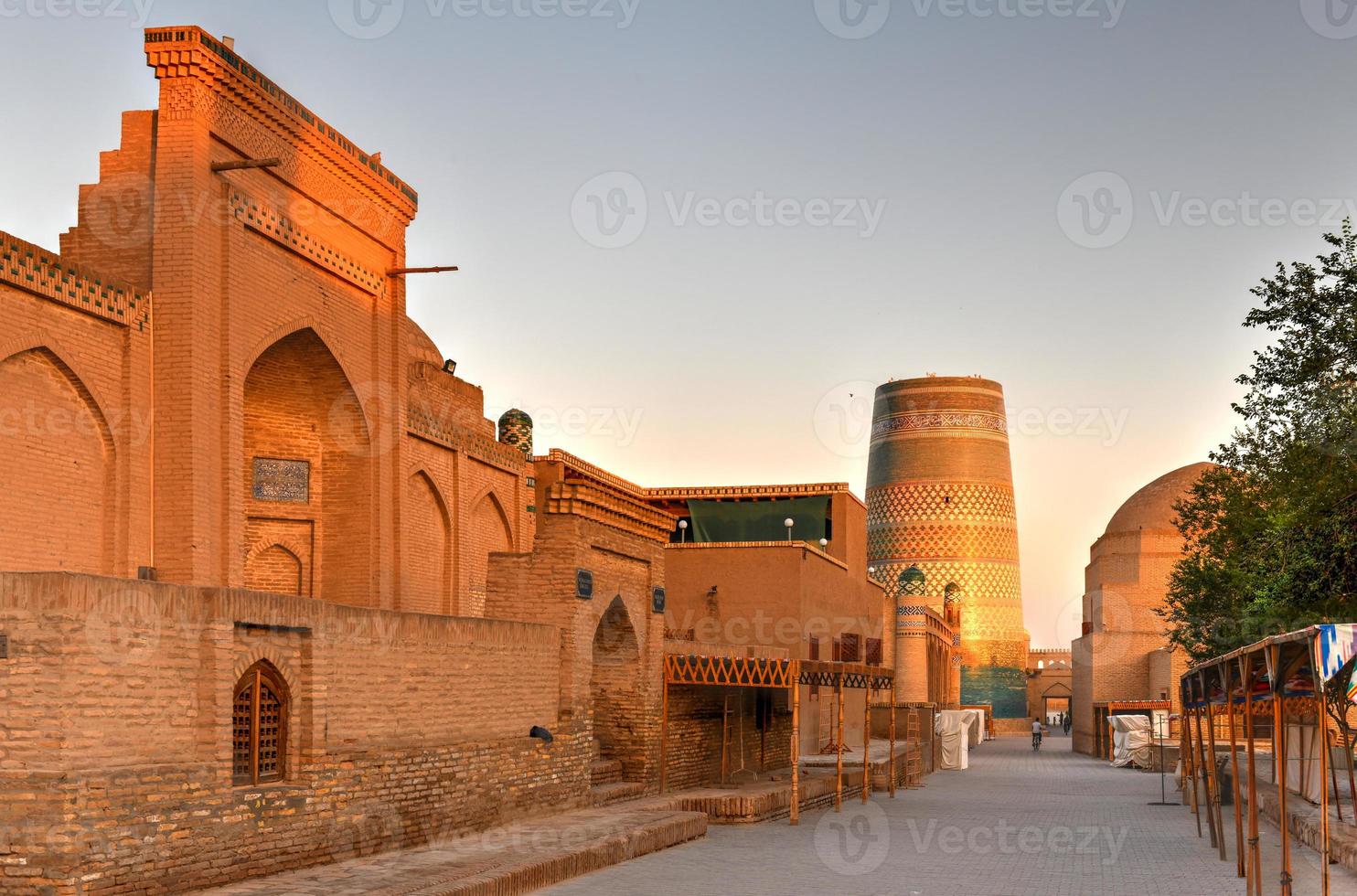 Minarett von Kalta Minor und die historische Architektur von Itchan Kala, der ummauerten Innenstadt der Stadt Chiwa, Usbekistan, die zum UNESCO-Weltkulturerbe gehört. foto