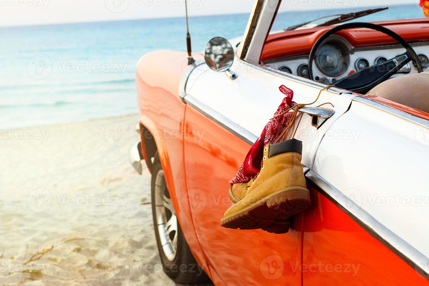 Auto mit gebundenen Stiefeln und Kopftuch an einer Türklinke am Strand foto