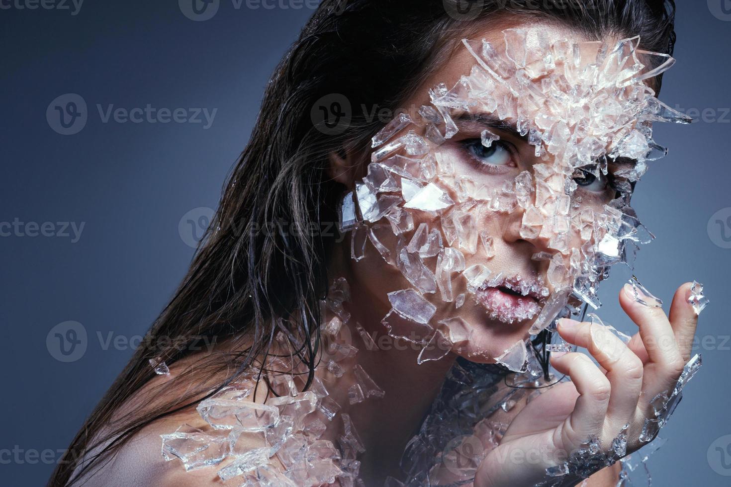 weibliches gesicht mit kleinen glasstücken bedeckt foto