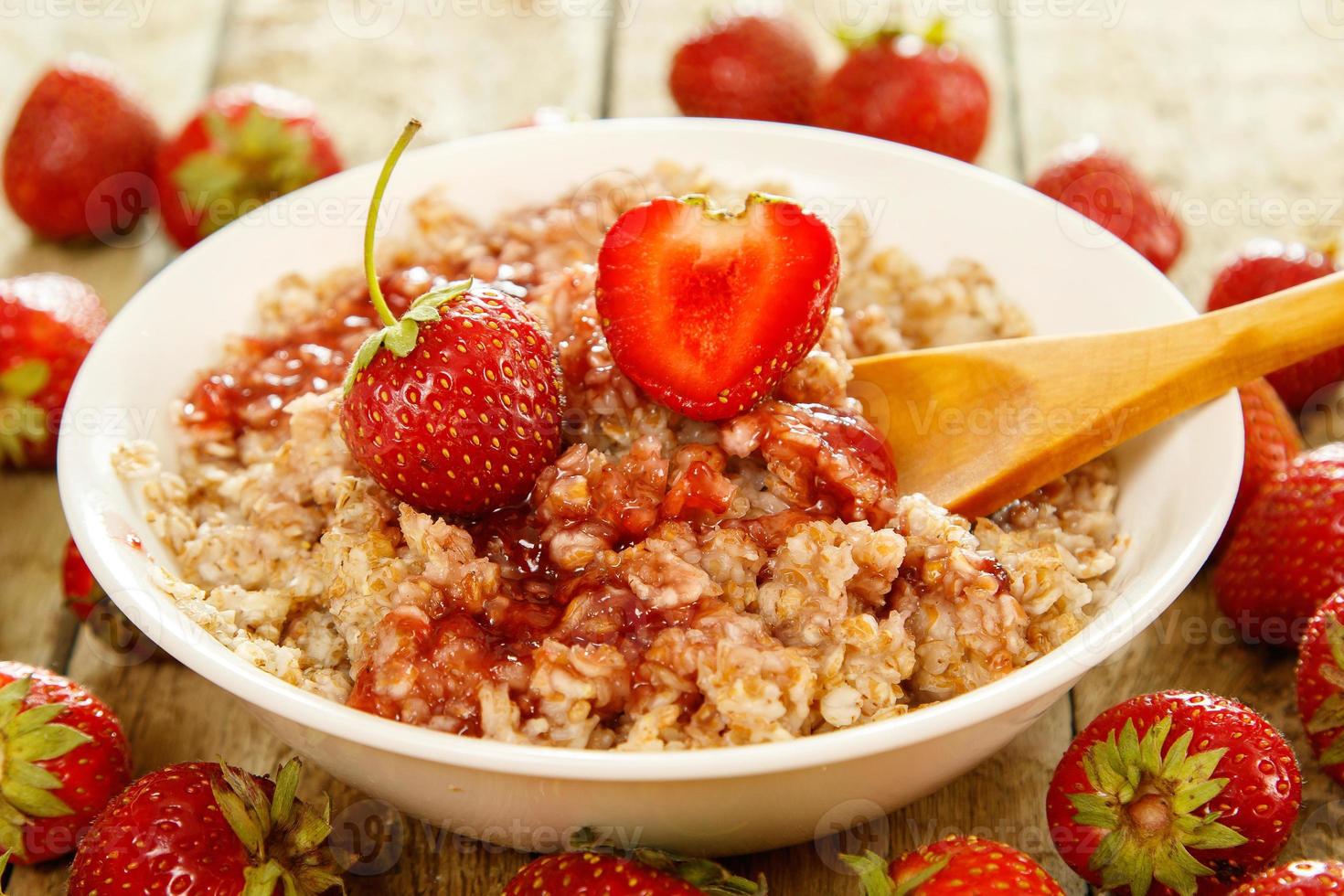 gekochte Haferflocken, Beeren und Erdbeermarmelade auf dem Tisch foto