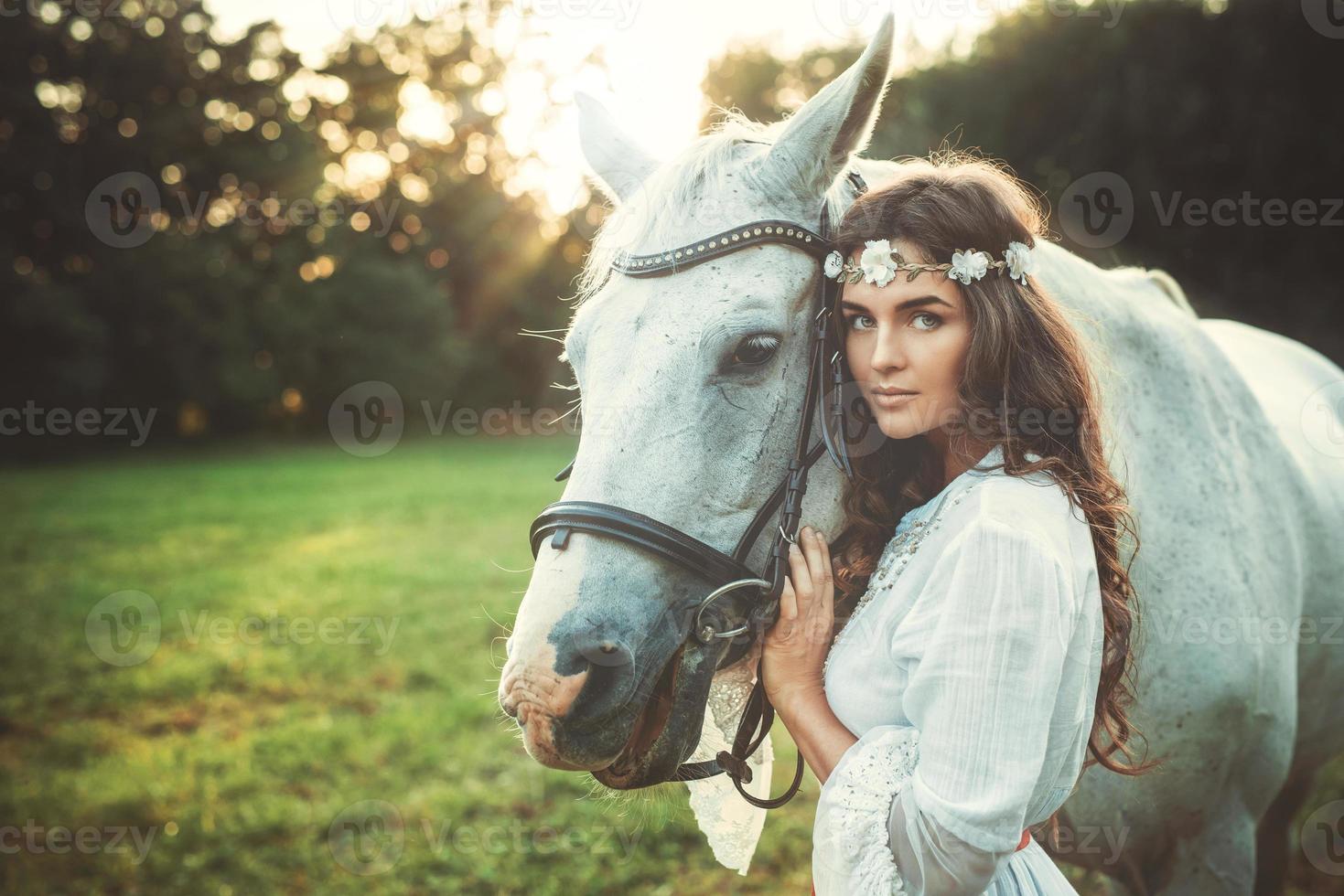 Frau im schönen weißen Kleid und ihr schönes Pferd foto