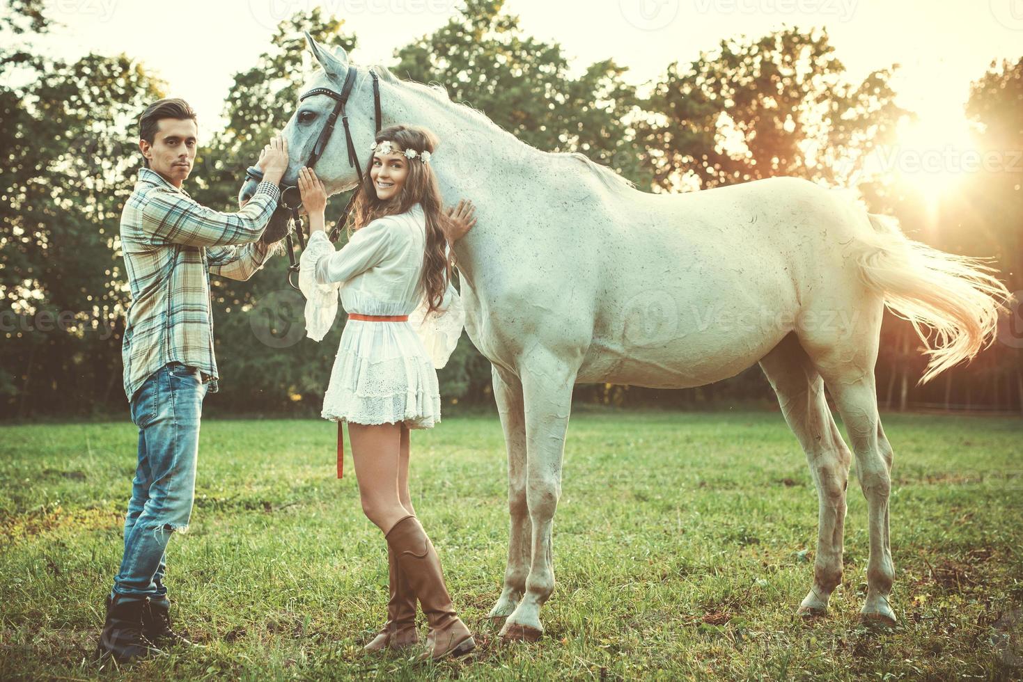junges glückliches paar und schönes weißes pferd foto