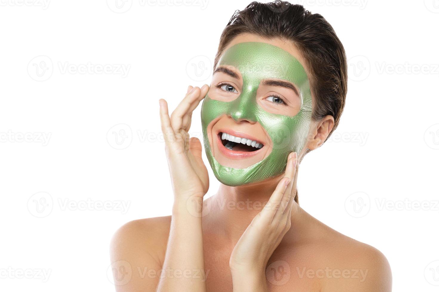 Frau mit grüner Abziehmaske im Gesicht foto