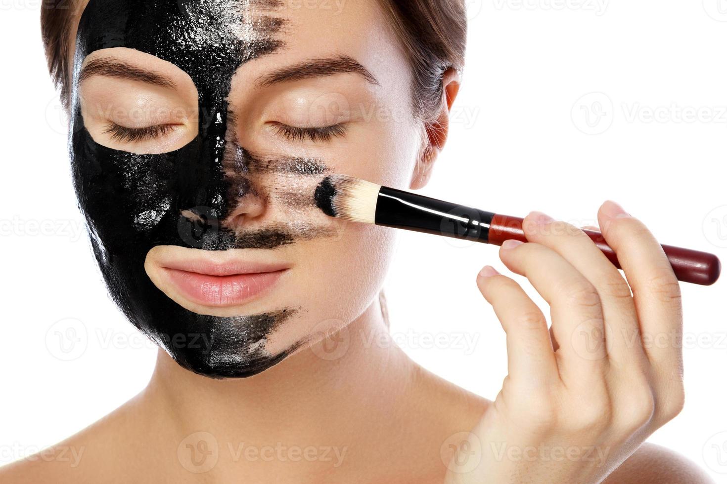 schöne frau trägt reinigende schwarze maske auf ihr gesicht auf foto