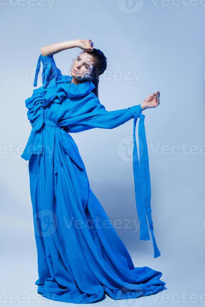 frau mit einem stück auf ihrem gesicht, das blaues kleid trägt foto