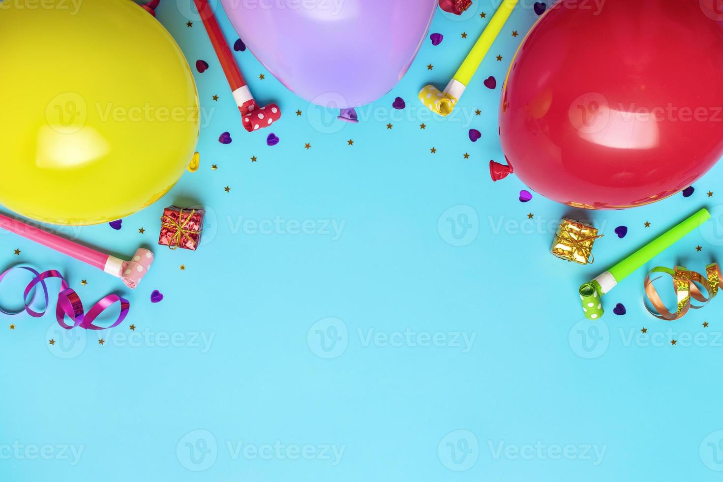 bunter partyrahmen mit roter geschenkbox mit verschiedenen partykonfetti, luftballons, luftschlangen, pokern und dekorationen auf blauem hintergrund. urlaubskarte flach draufsicht alles gute zum geburtstag partykonzept foto