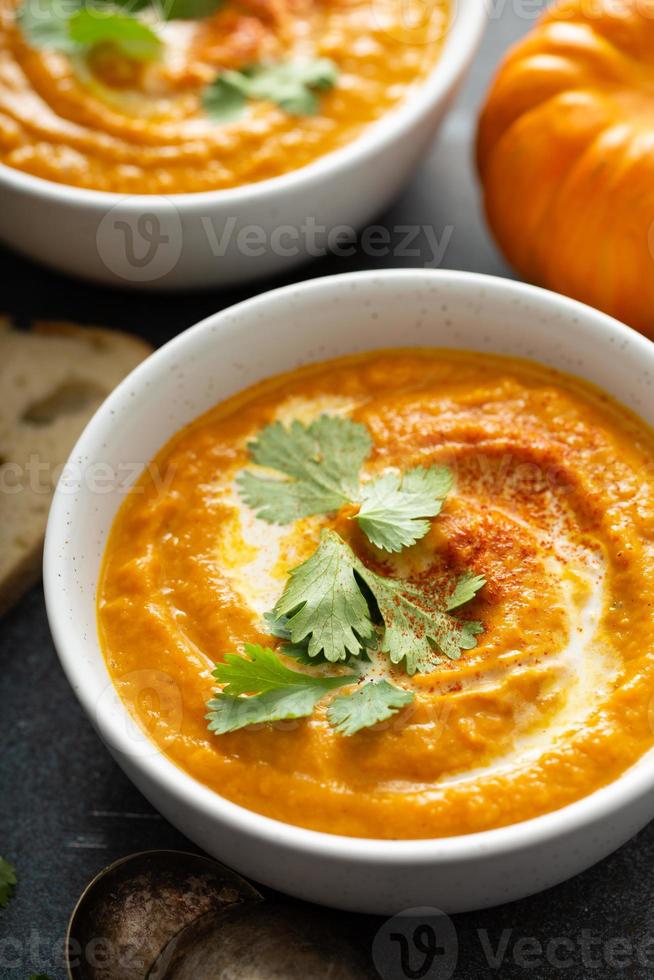 Kürbissuppe serviert mit Sahne und Koriander foto