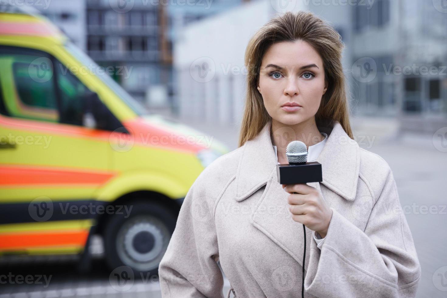 besorgter nachrichtenreporter, der in ein mikrofon spricht foto