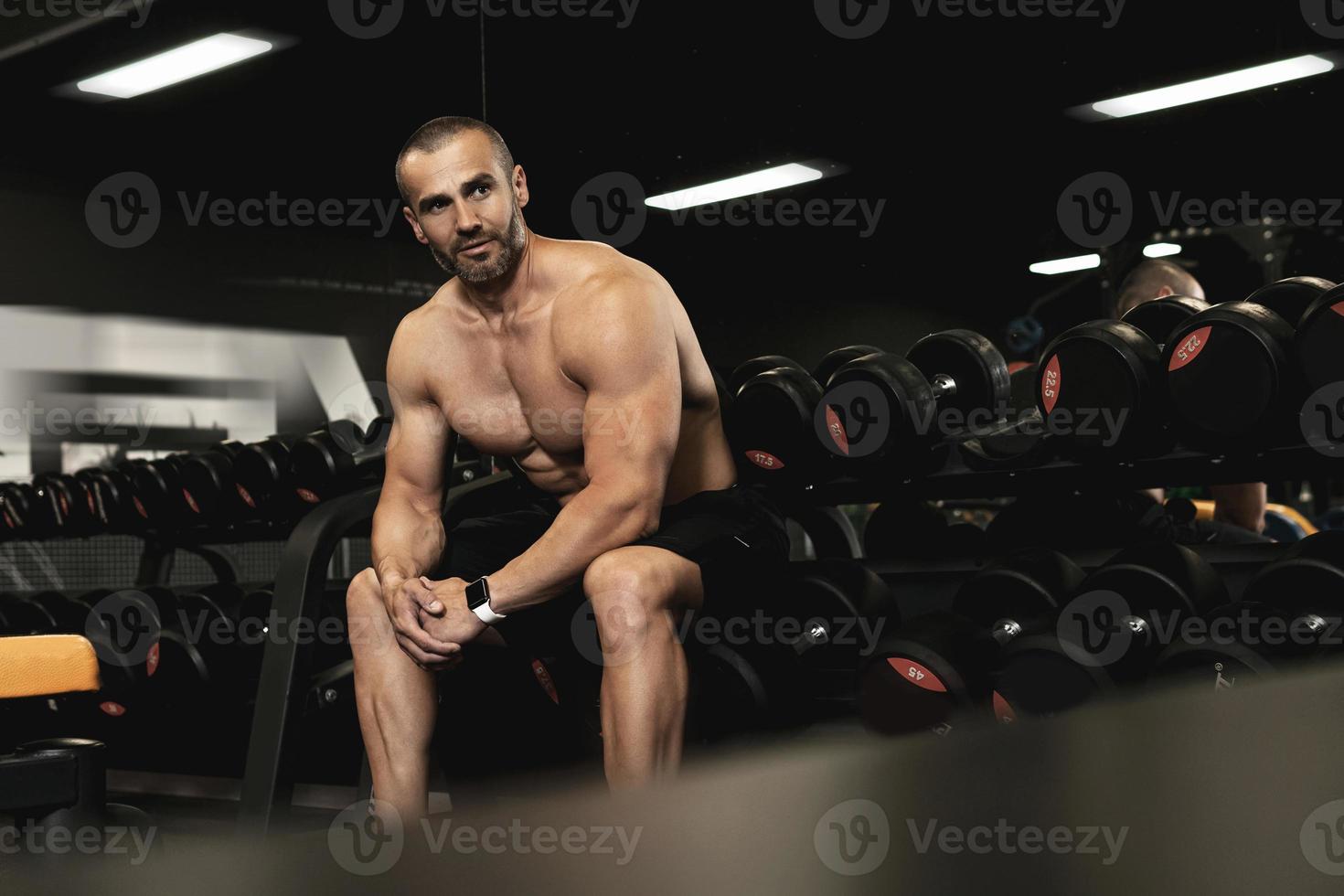 muskulöser Bodybuilder in einer Freihantelzone im Fitnessstudio foto