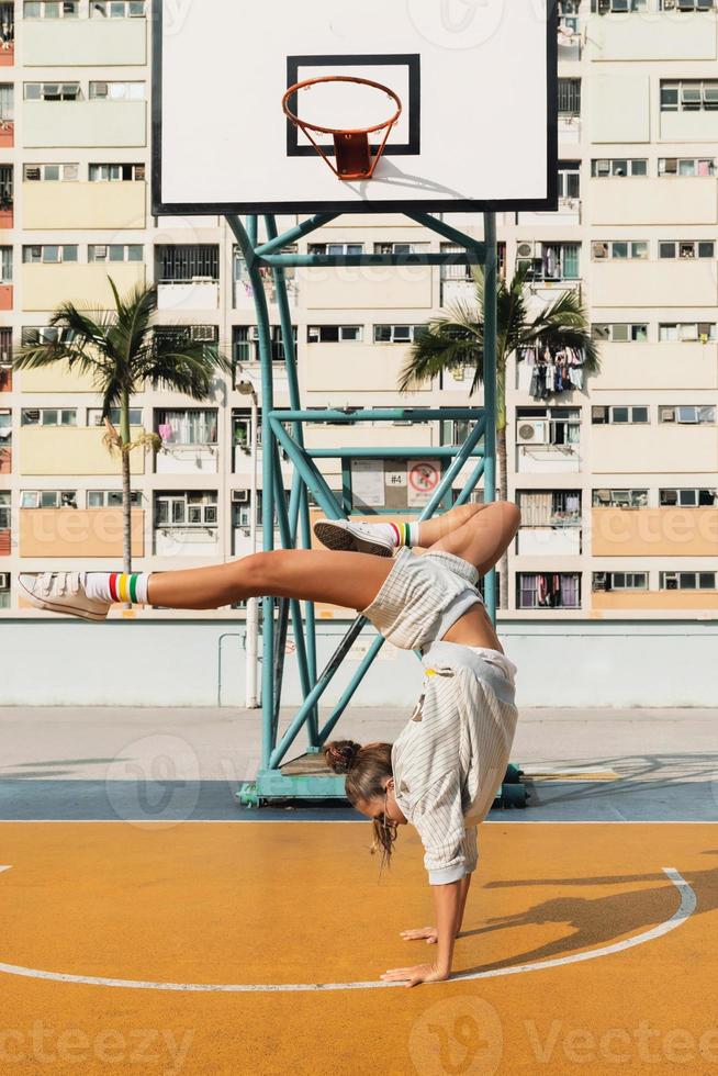 Junge stilvolle Frau posiert auf dem Basketballplatz des Choi Hung Estate foto