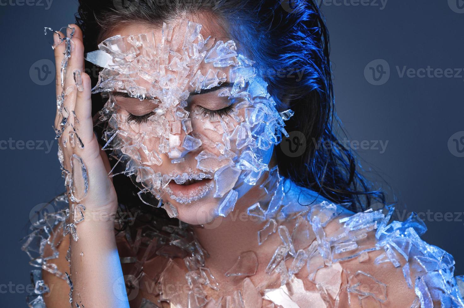 weibliches Gesicht mit vielen kleinen Glas- oder Eisstücken bedeckt foto