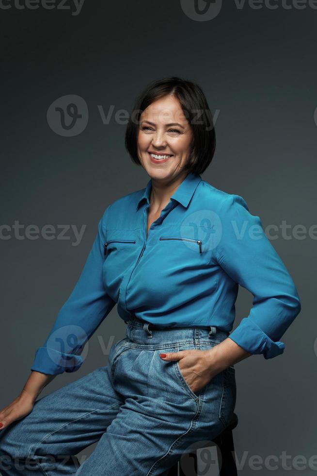 schöne Frau mittleren Alters mit blauem Hemd foto