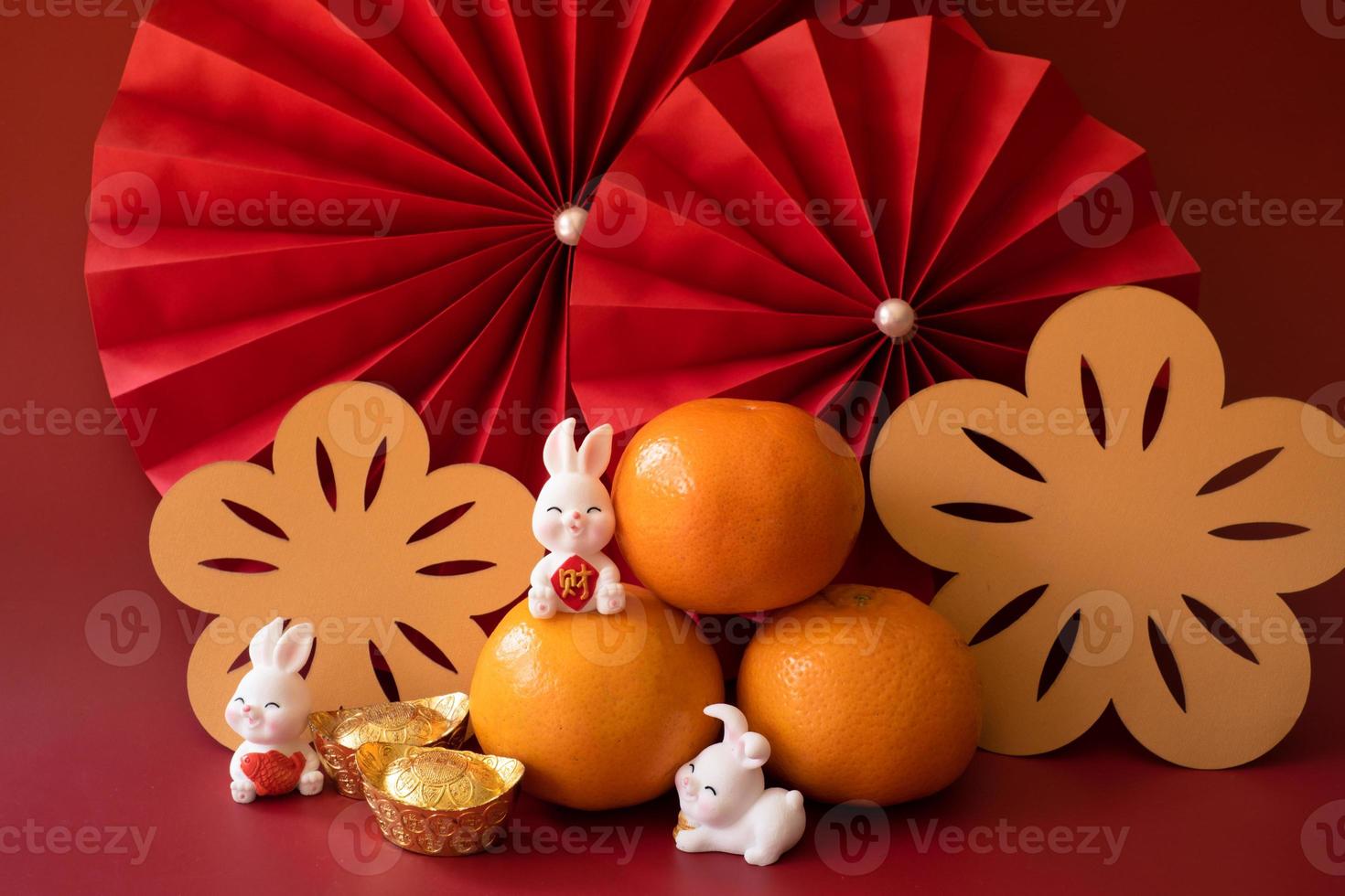 chinesisches neujahr des kaninchenfestivalkonzepts. Mandarinorange, rote Umschläge, Kaninchen und Goldbarren mit roten Papierfächern. traditionelles feiertags-mondneujahr. chinesisches schriftzeichen cai bedeutet geld. foto