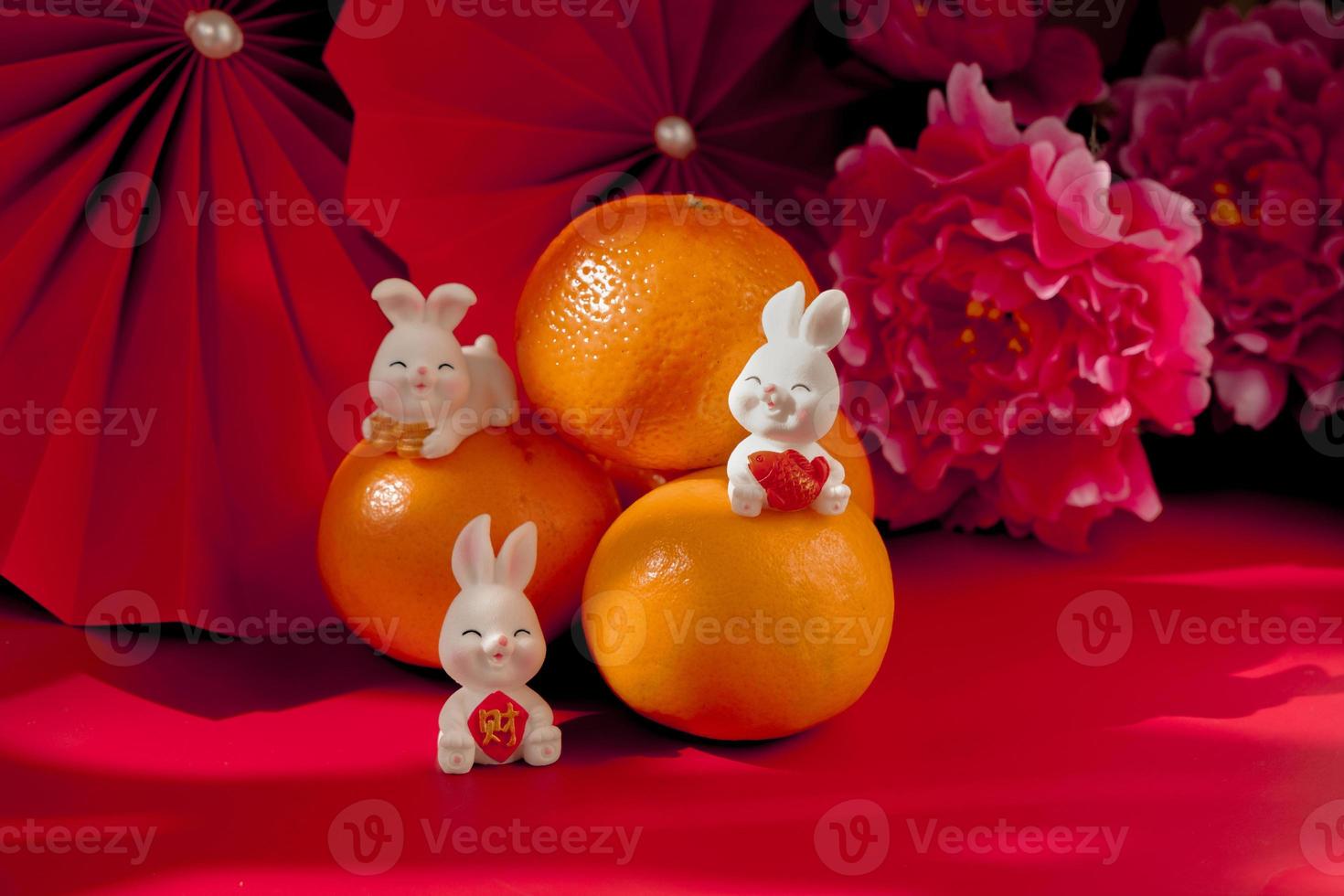 chinesisches neujahr des kaninchenfestivalkonzepts. Mandarinorange, rote Umschläge, Kaninchen und Goldbarren mit roten Papierfächern. traditionelles feiertags-mondneujahr. chinesisches schriftzeichen cai bedeutet geld. foto
