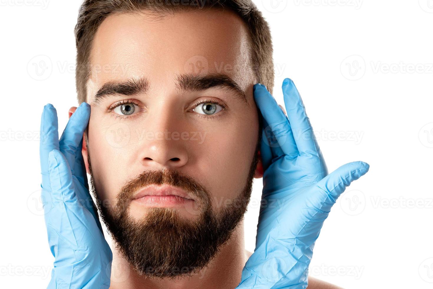 Schöner Mann während der Untersuchung vor einer plastischen Operation foto