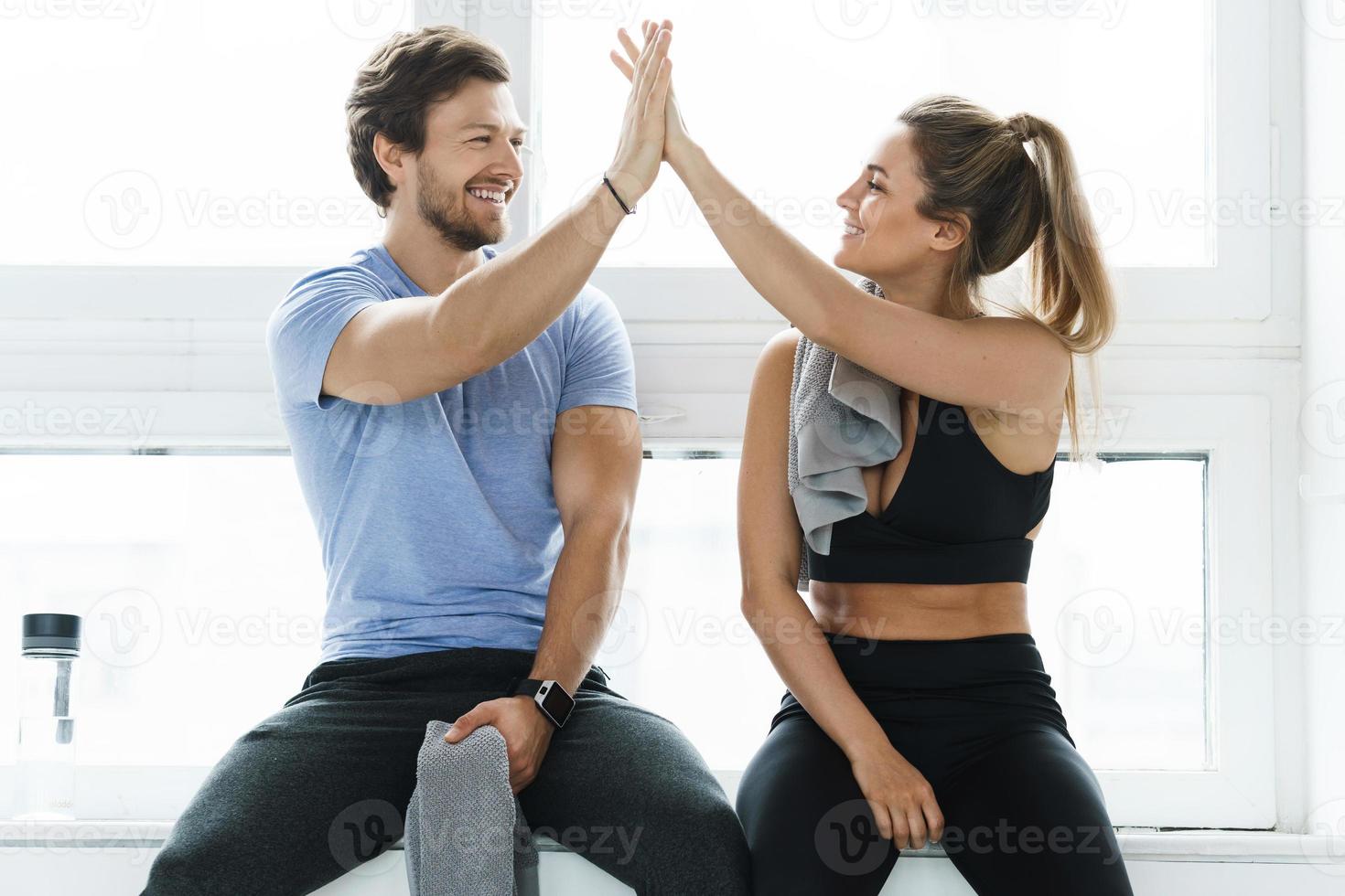 high five zwischen mann und frau im fitnessstudio nach dem fitnesstraining foto