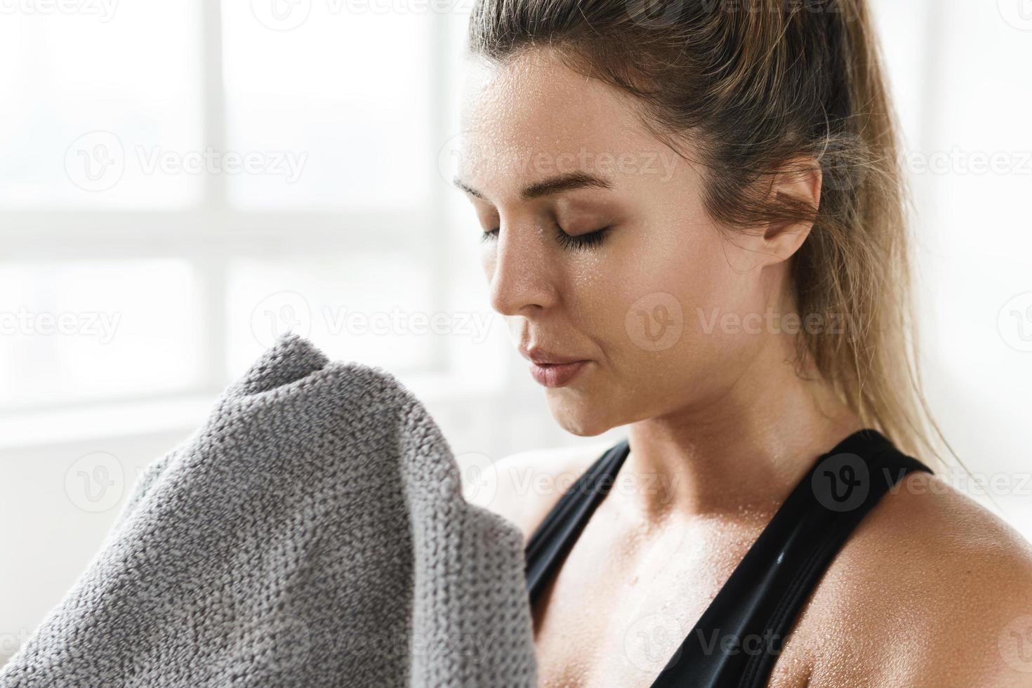 müde frau mit einem handtuch nach dem fitnesstraining im fitnessstudio foto