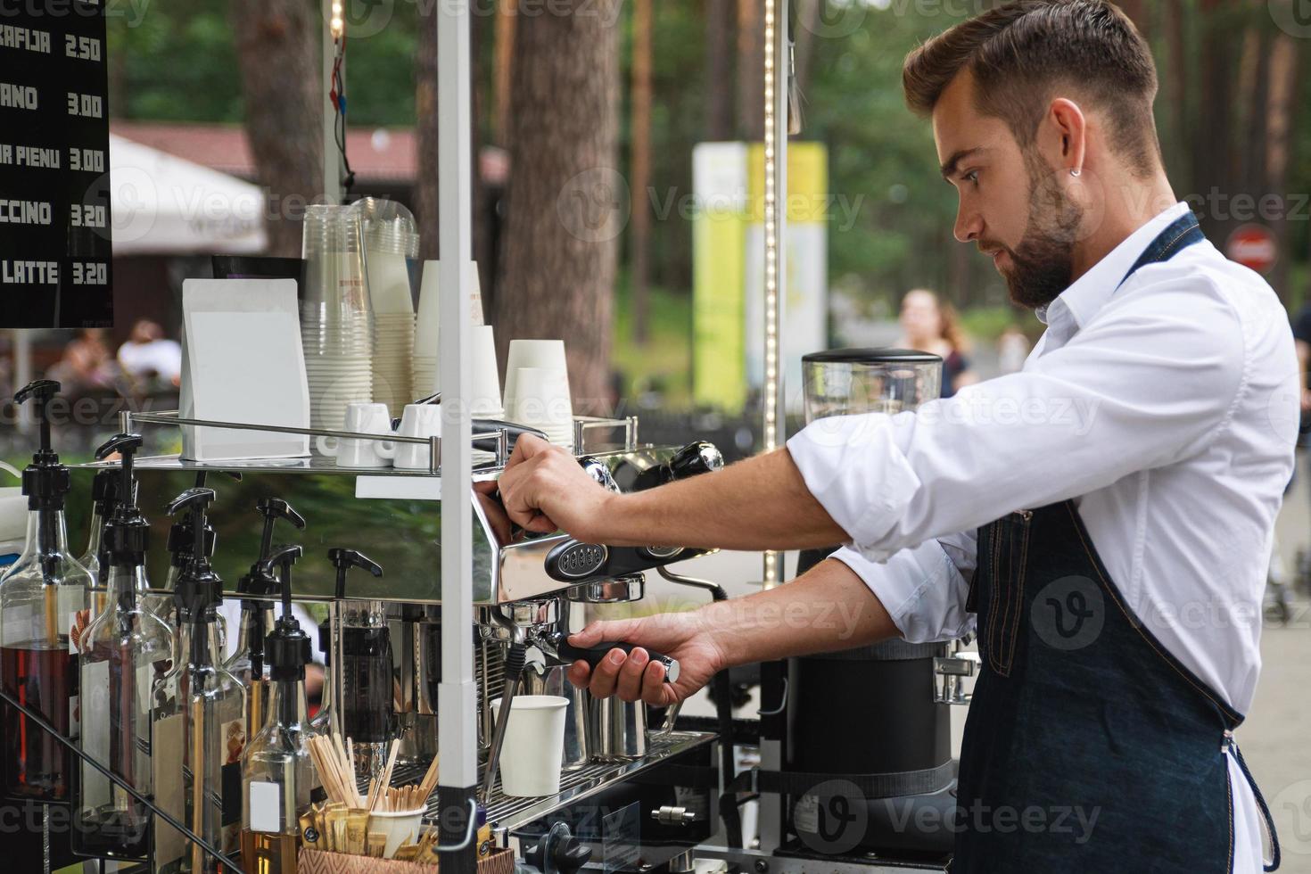 Gutaussehender Barista-Mann während der Arbeit in seinem Straßencafé foto