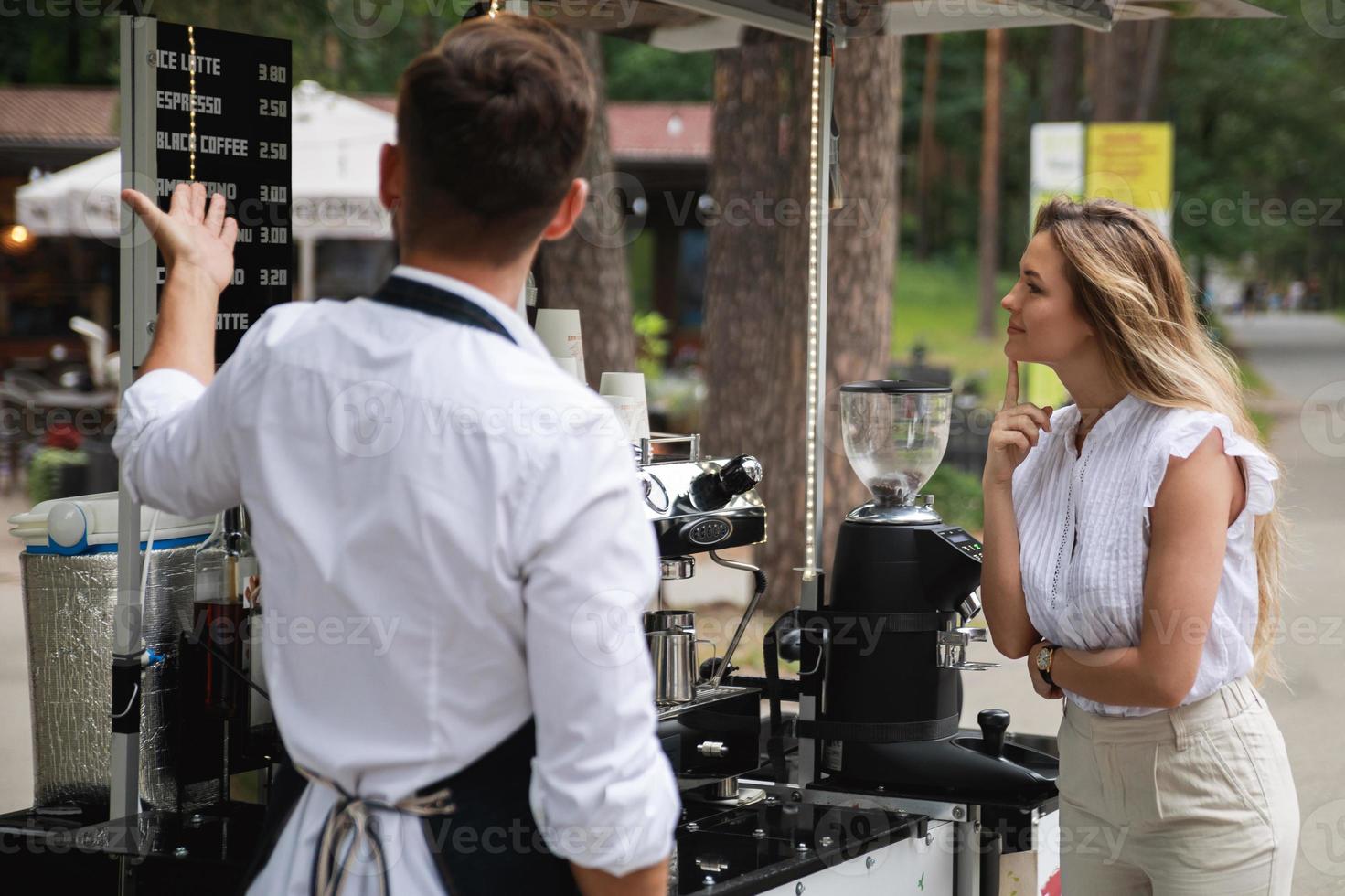 Barista-Mann bietet der Kundin verschiedene Kaffeesorten an foto