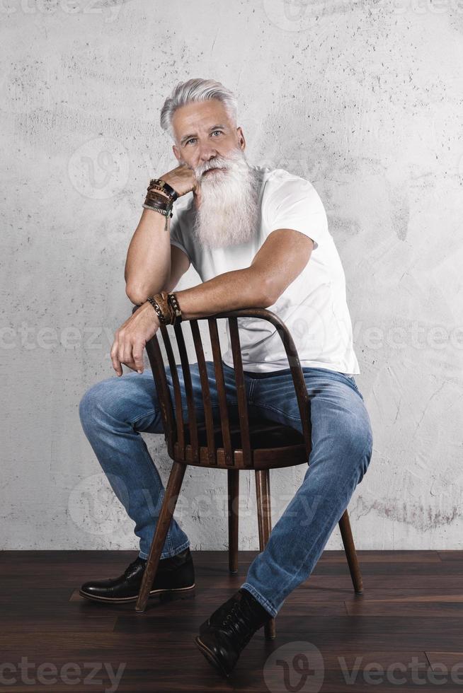 hübscher bärtiger älterer mann, der im studio aufwirft foto