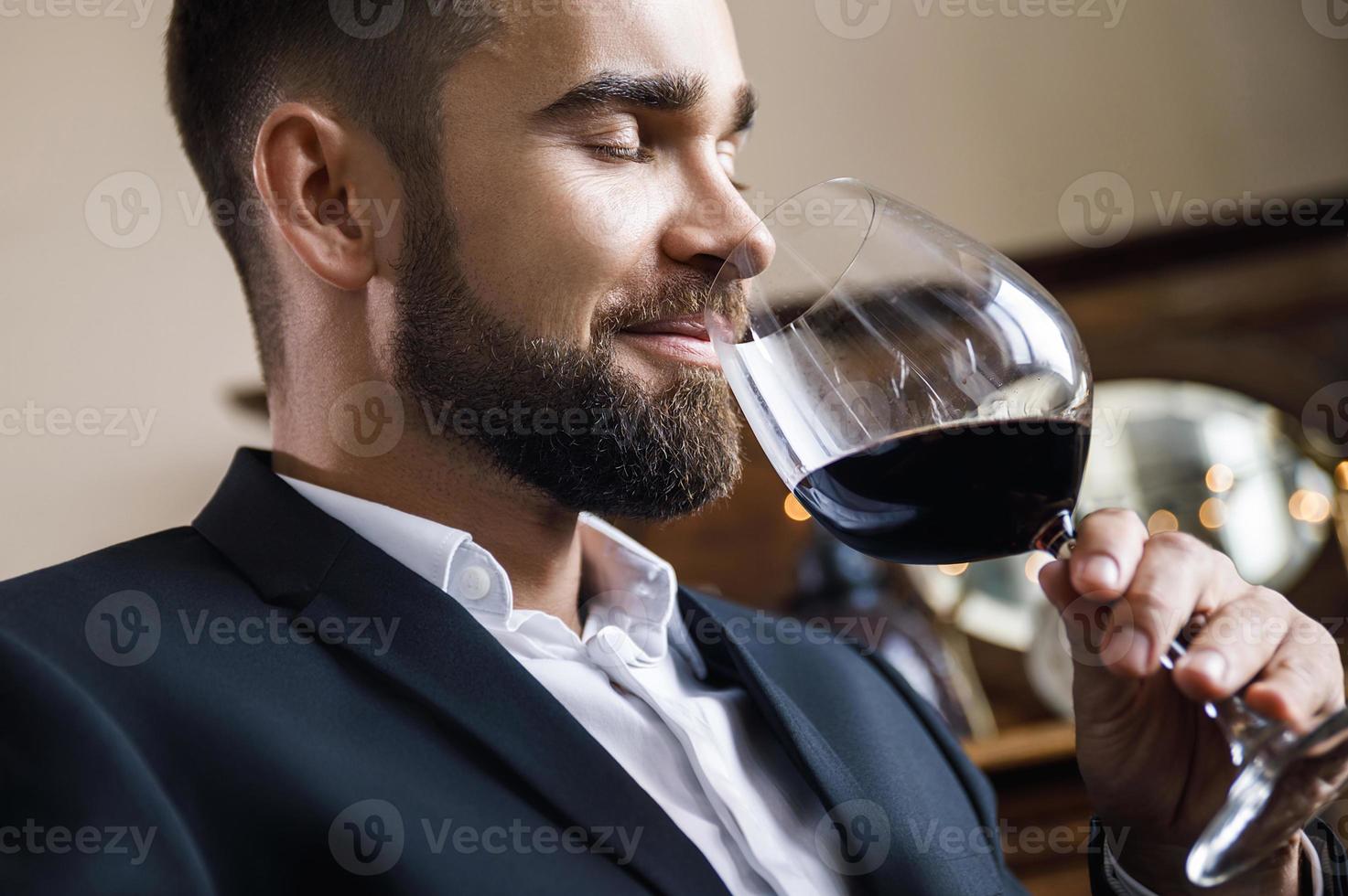 hübscher bärtiger mann mit einem glas rotwein foto