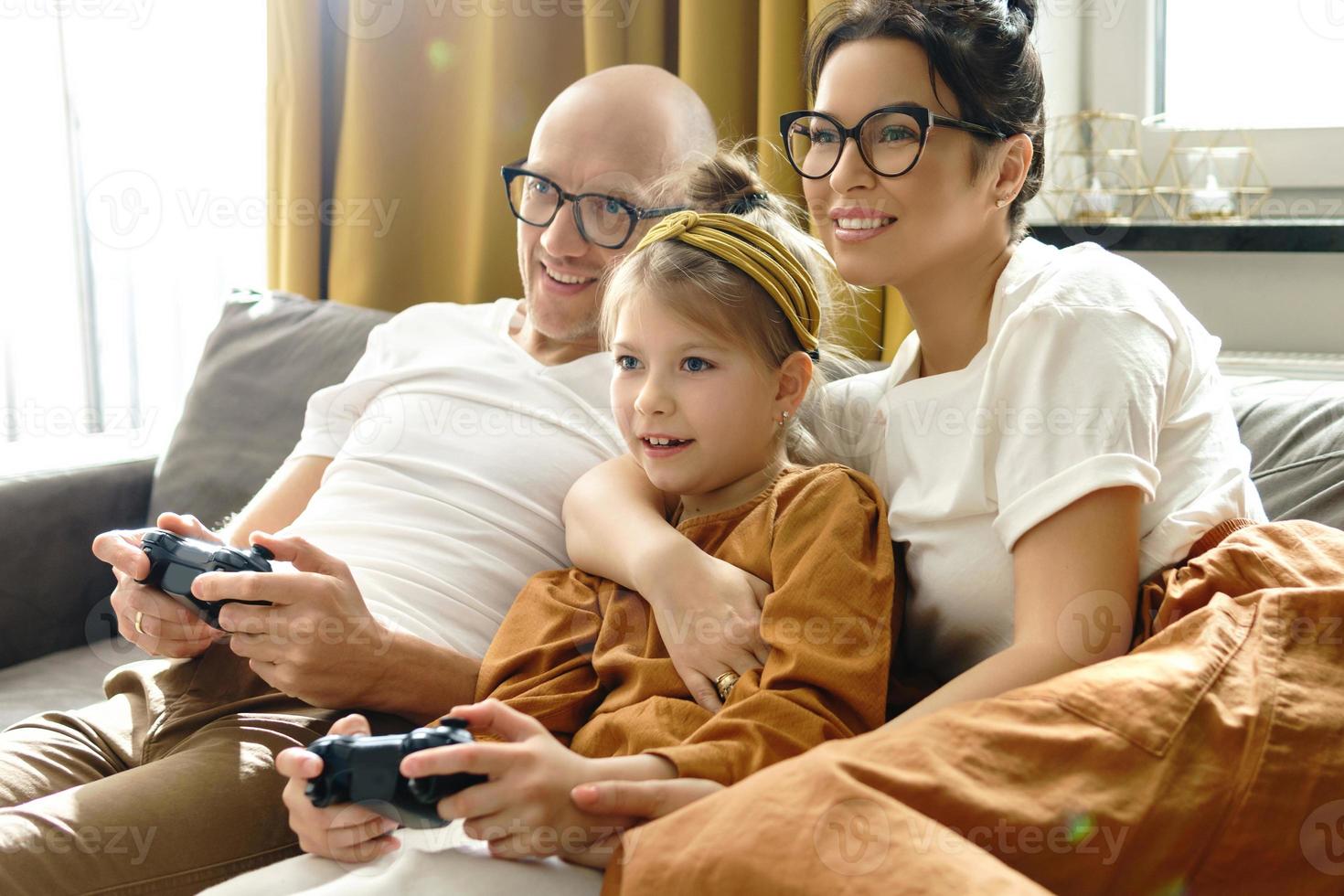 Glückliche Familie spielt zu Hause eine Videospielkonsole foto