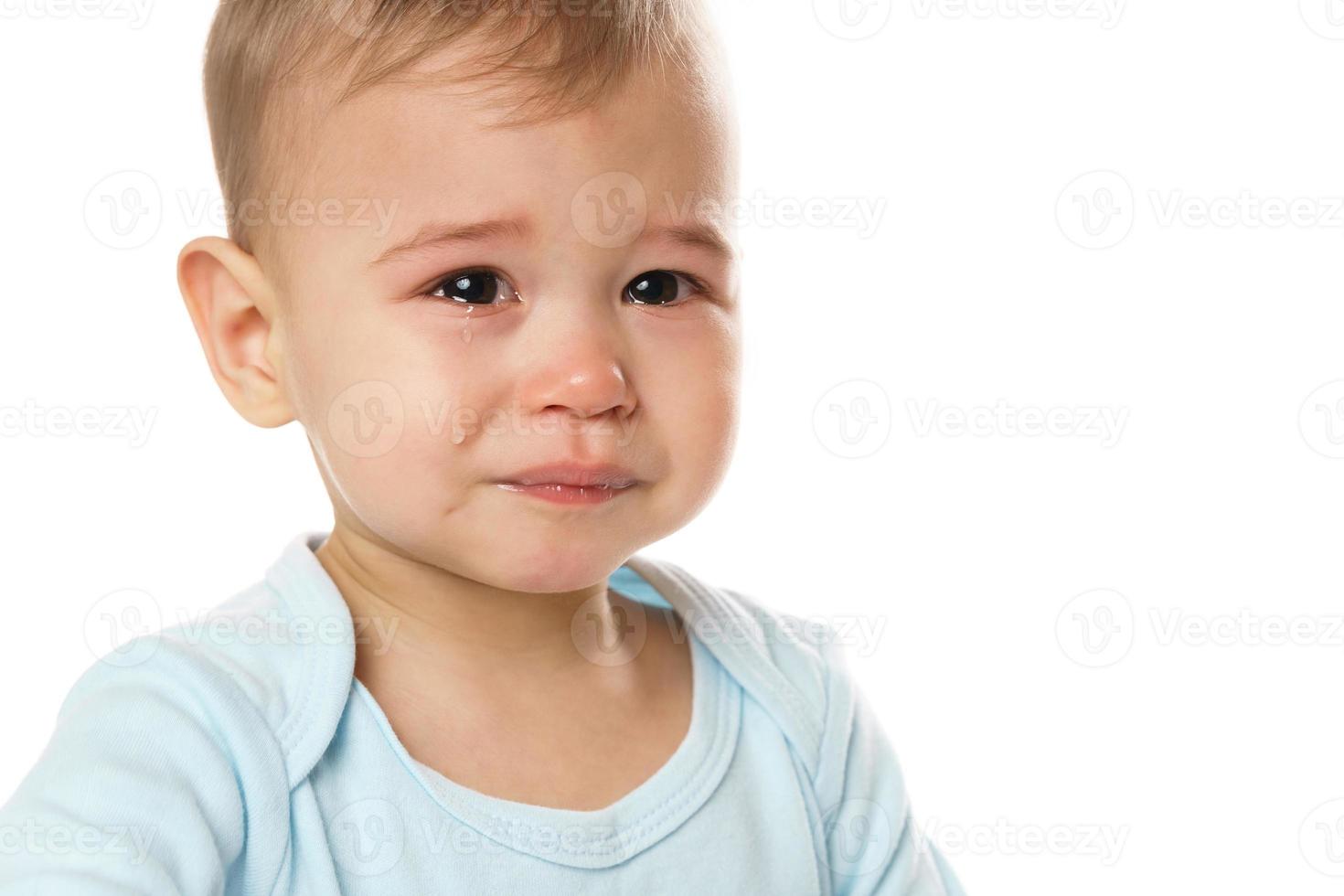 Nahaufnahme des Gesichts eines weinenden kleinen Jungen im Strampler. foto