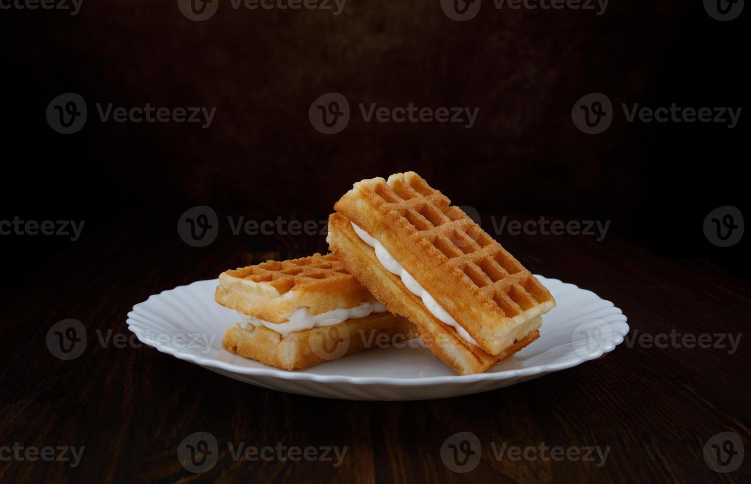 frische Wiener Waffeln mit weißer Sahne auf einem weißen Teller. foto