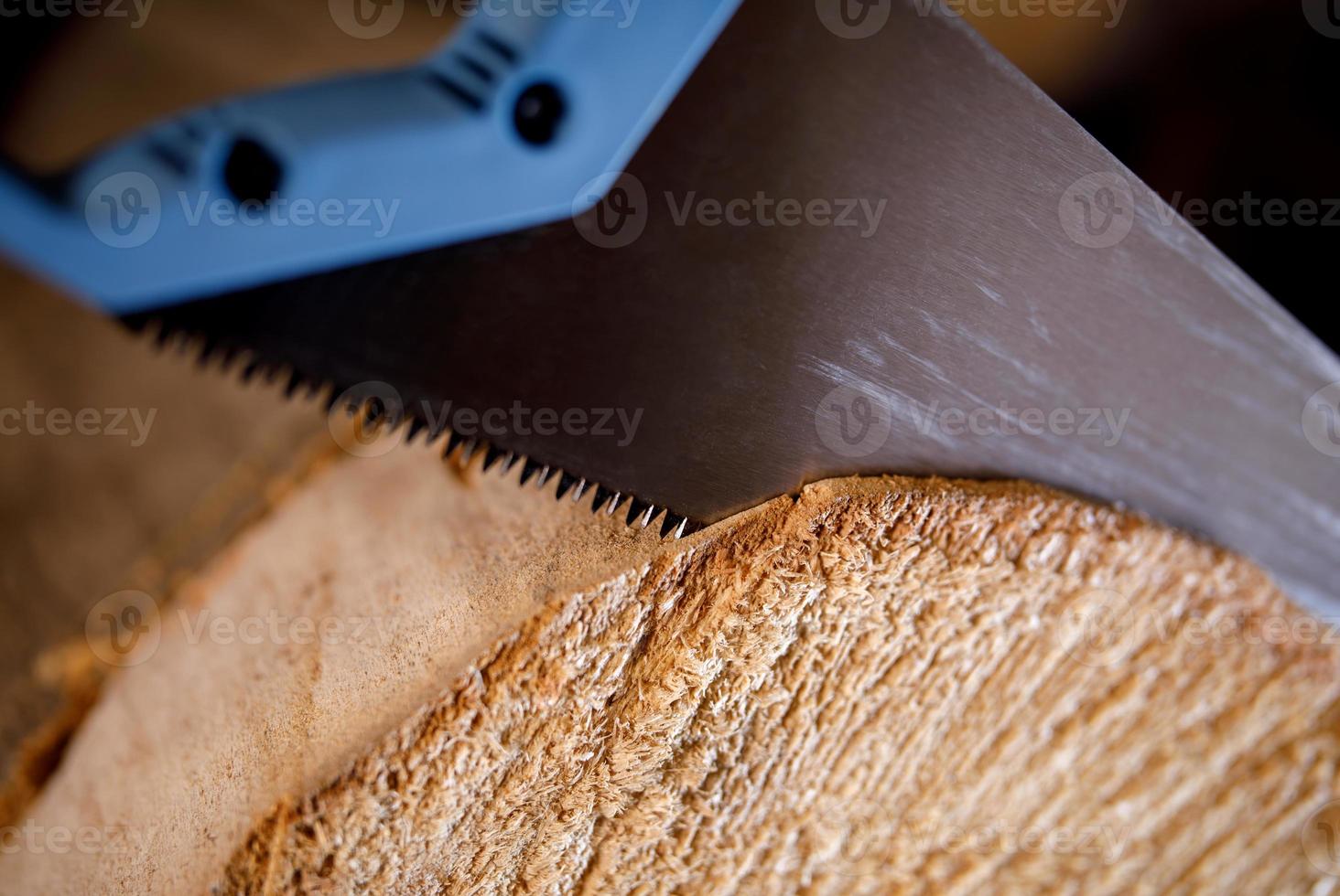 Handbügelsäge an einem Baum sägt einen Baumstamm. Nahaufnahme von Sägezähnen auf Holz. foto