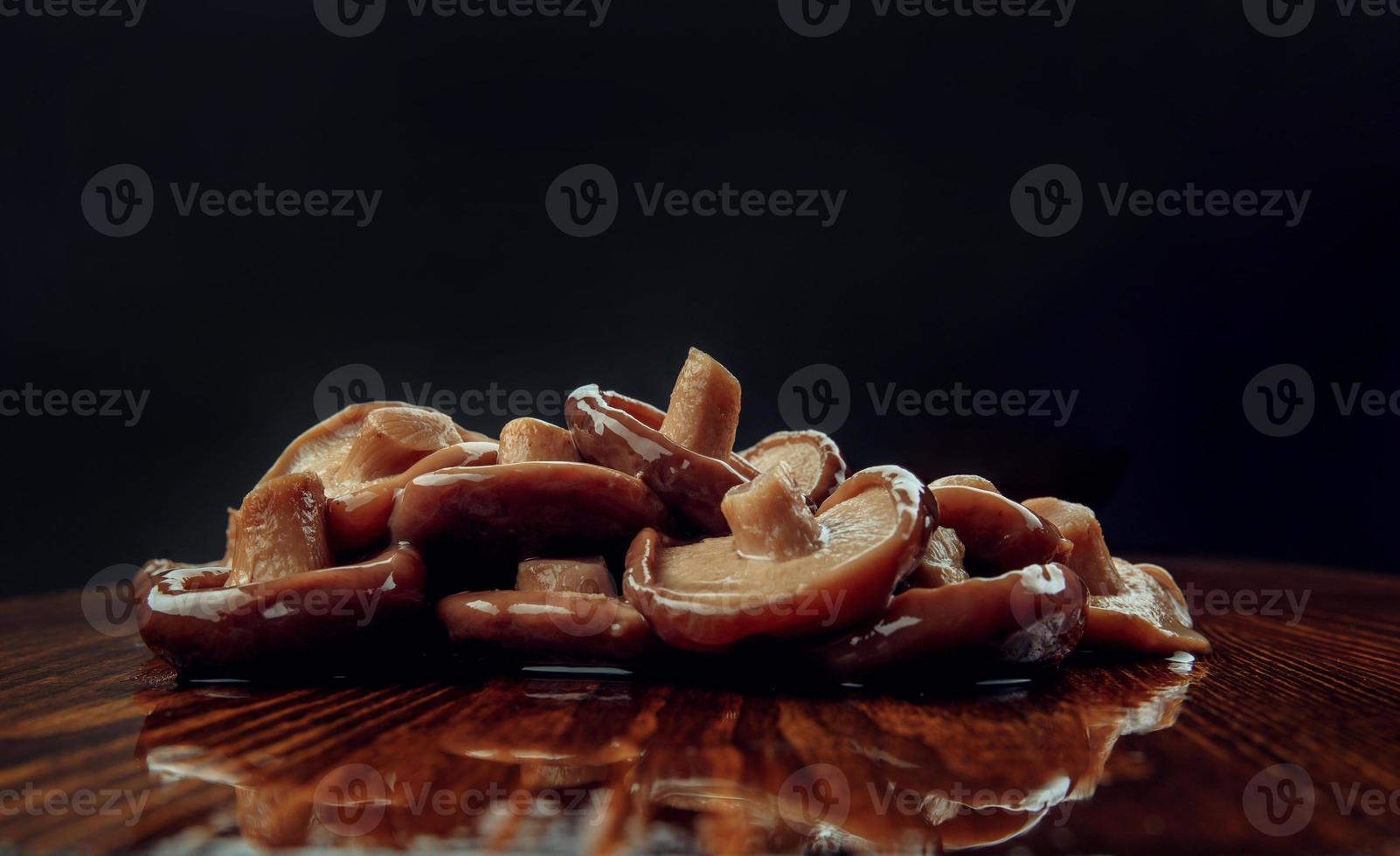 eine Streuung eingelegter Pilze auf einem Holztisch. Gesundes Dorfessen. salziger schwarzer Milchpilz. foto