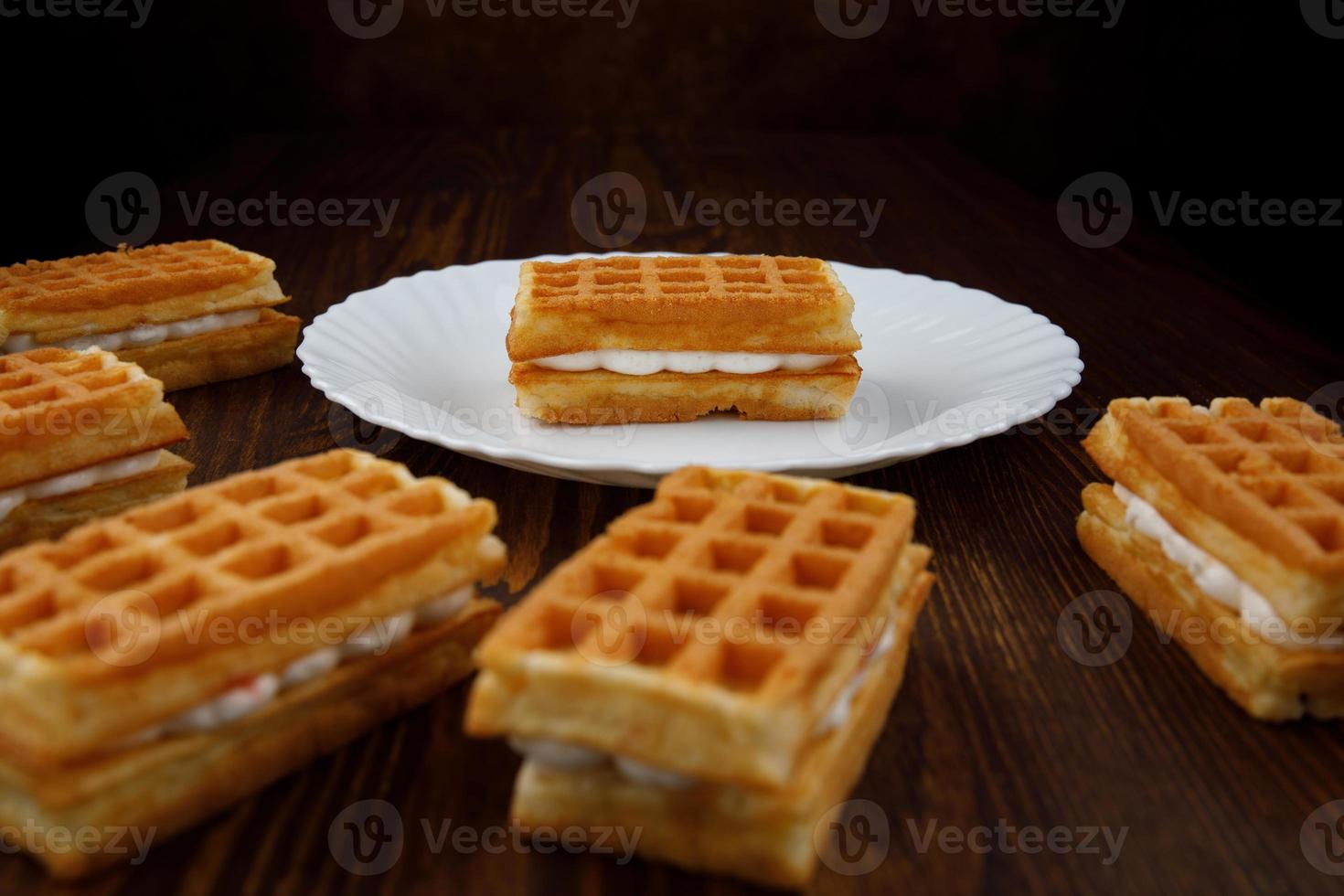 Wiener Waffeln liegen auf und neben einem weißen Teller. foto