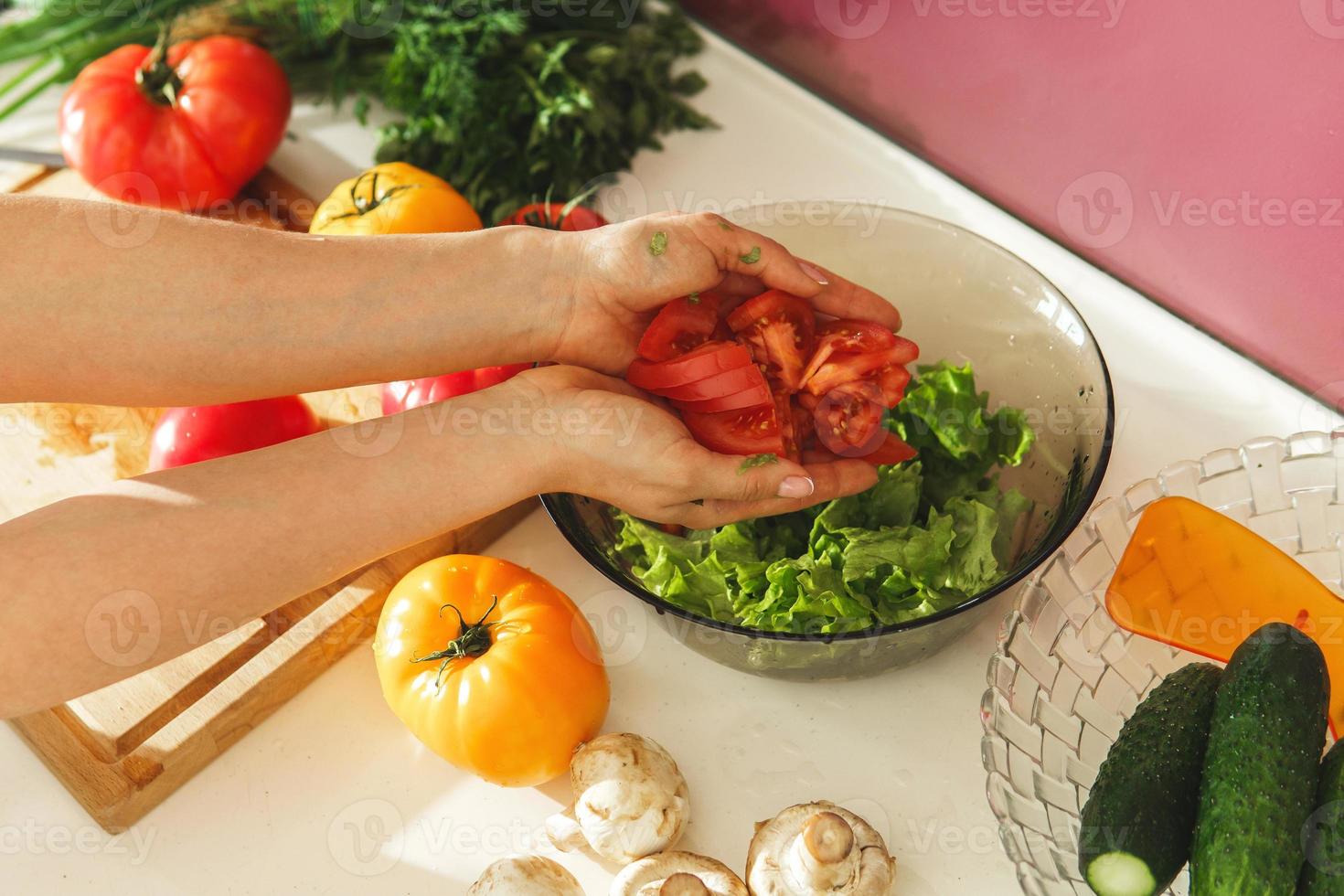 Frau kocht vegetarischen Salat mit frischem Gemüse foto