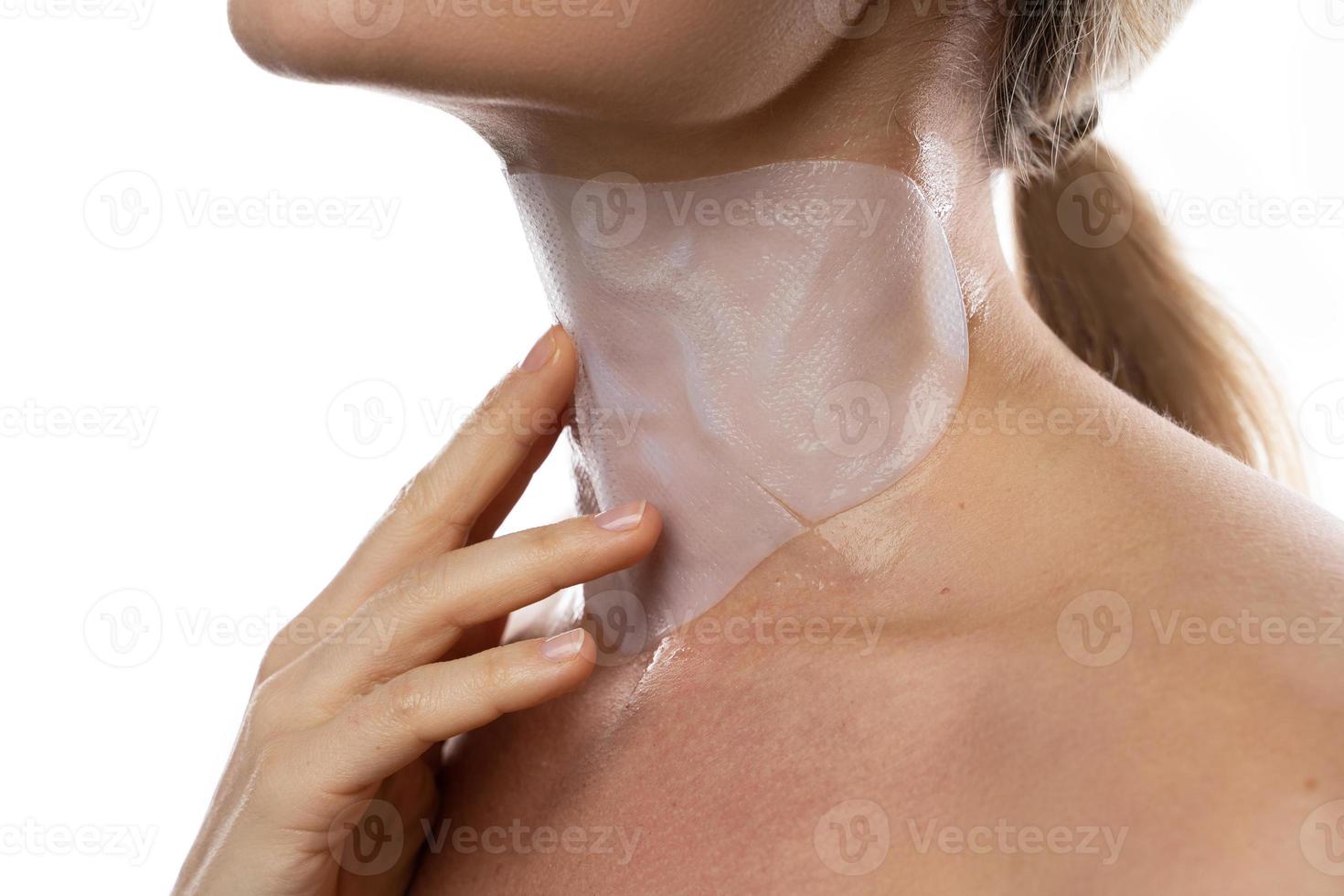 Frau mit einer feuchtigkeitsspendenden und Anti-Aging-Blattmaske auf dem Hals foto