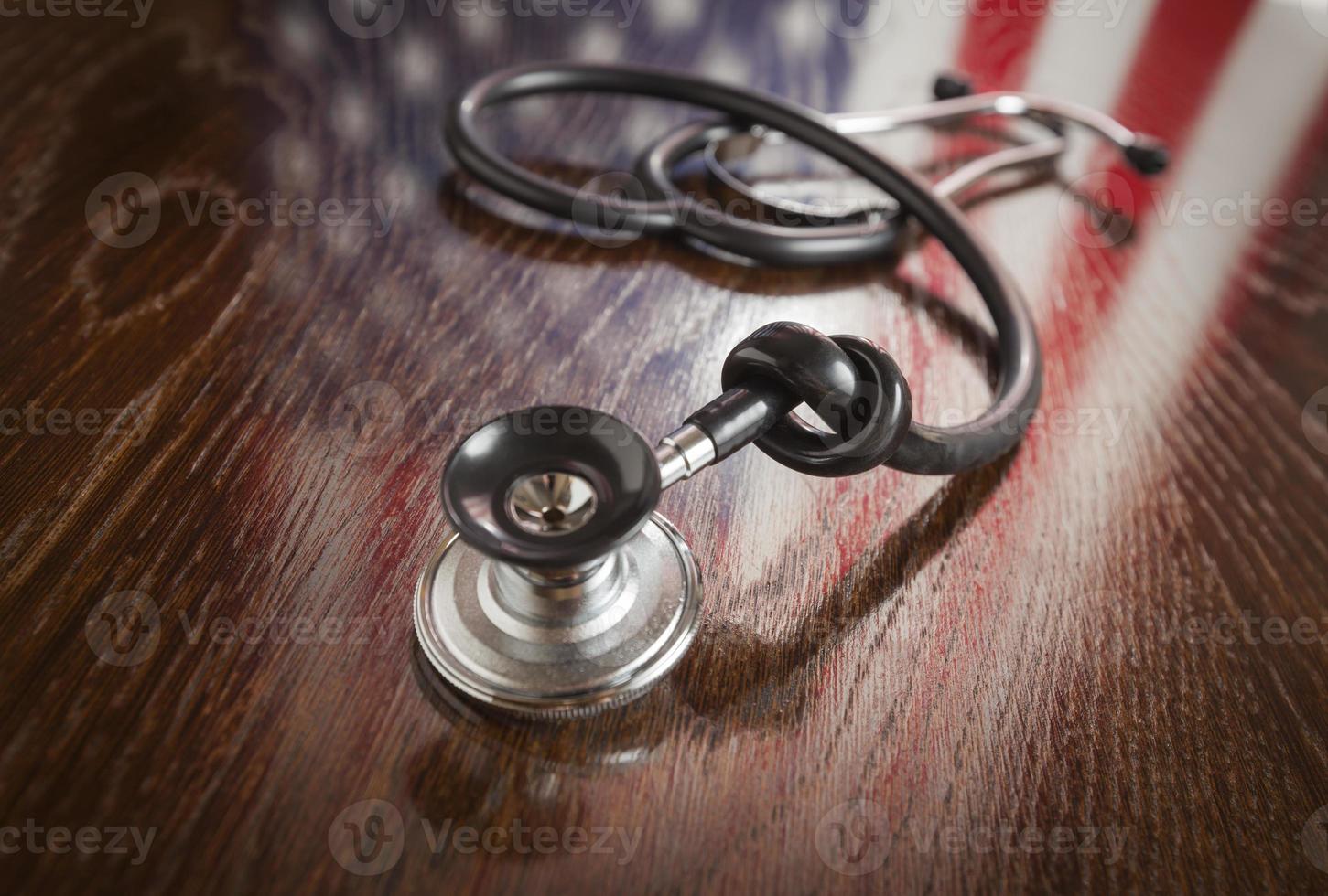 Geknotetes Stethoskop mit Reflexion der amerikanischen Flagge auf dem Tisch foto