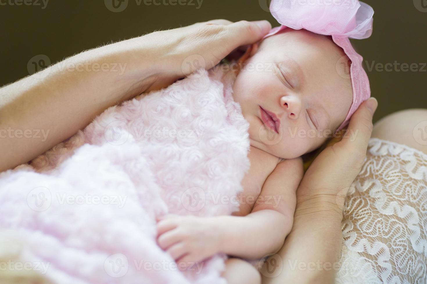 Hände der Mutter, die ihr neugeborenes Mädchen hält foto