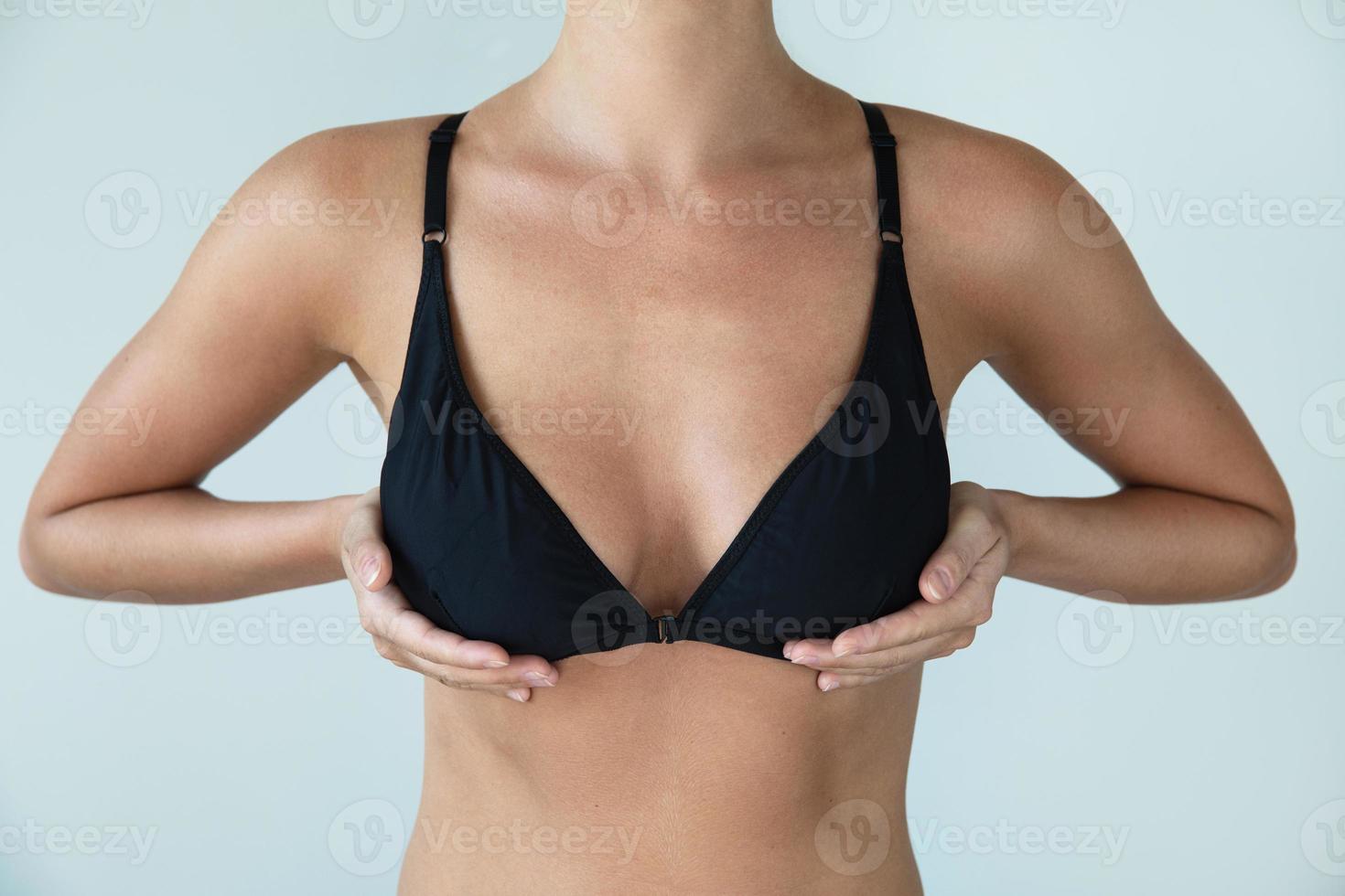frau mit natürlicher brust, die schwarzes badebekleidungsoberteil trägt foto