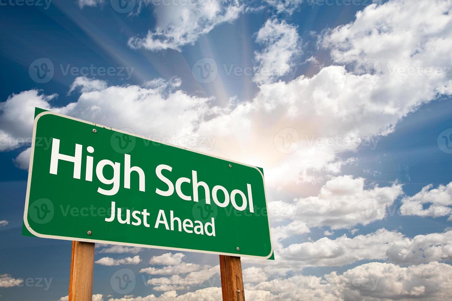 grünes Straßenschild der High School über Wolken foto