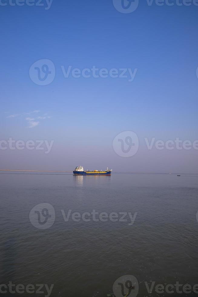 Landschaftsansicht eines kleinen Frachtschiffs vor blauem Himmel auf dem Fluss Padma in Bangladesch foto