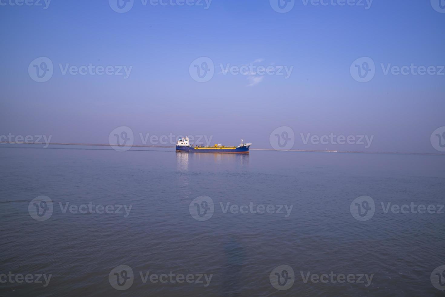 Landschaftsansicht eines kleinen Frachtschiffs vor blauem Himmel auf dem Fluss Padma in Bangladesch foto