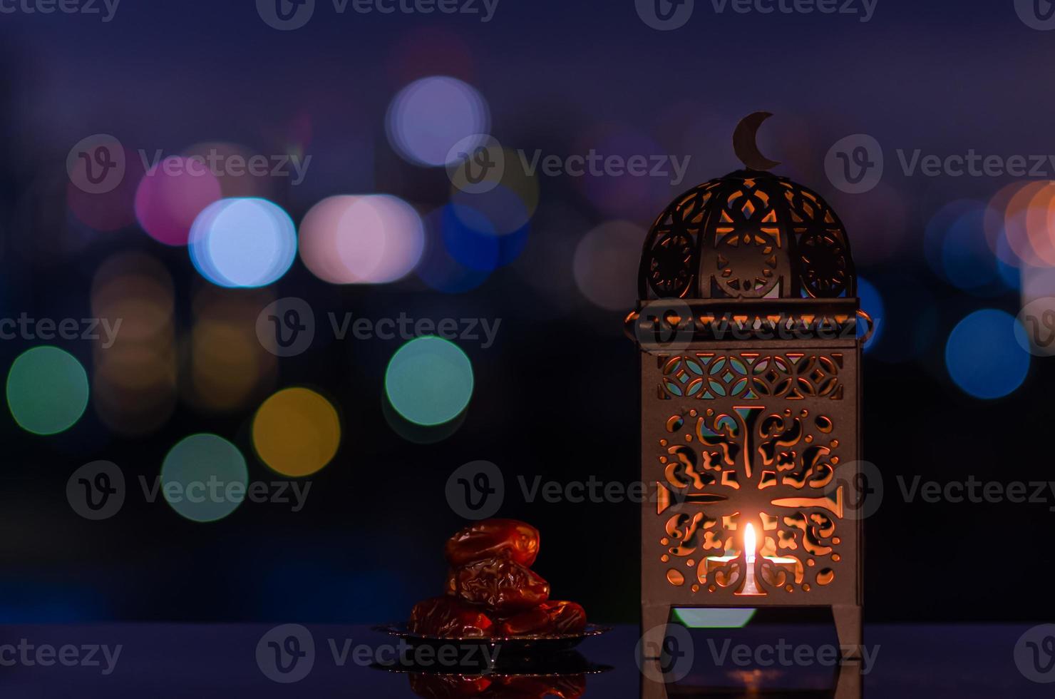 laterne und kleiner teller mit datteln obst mit nachthimmel und stadt bokeh heller hintergrund für das muslimische fest des heiligen monats ramadan kareem. foto