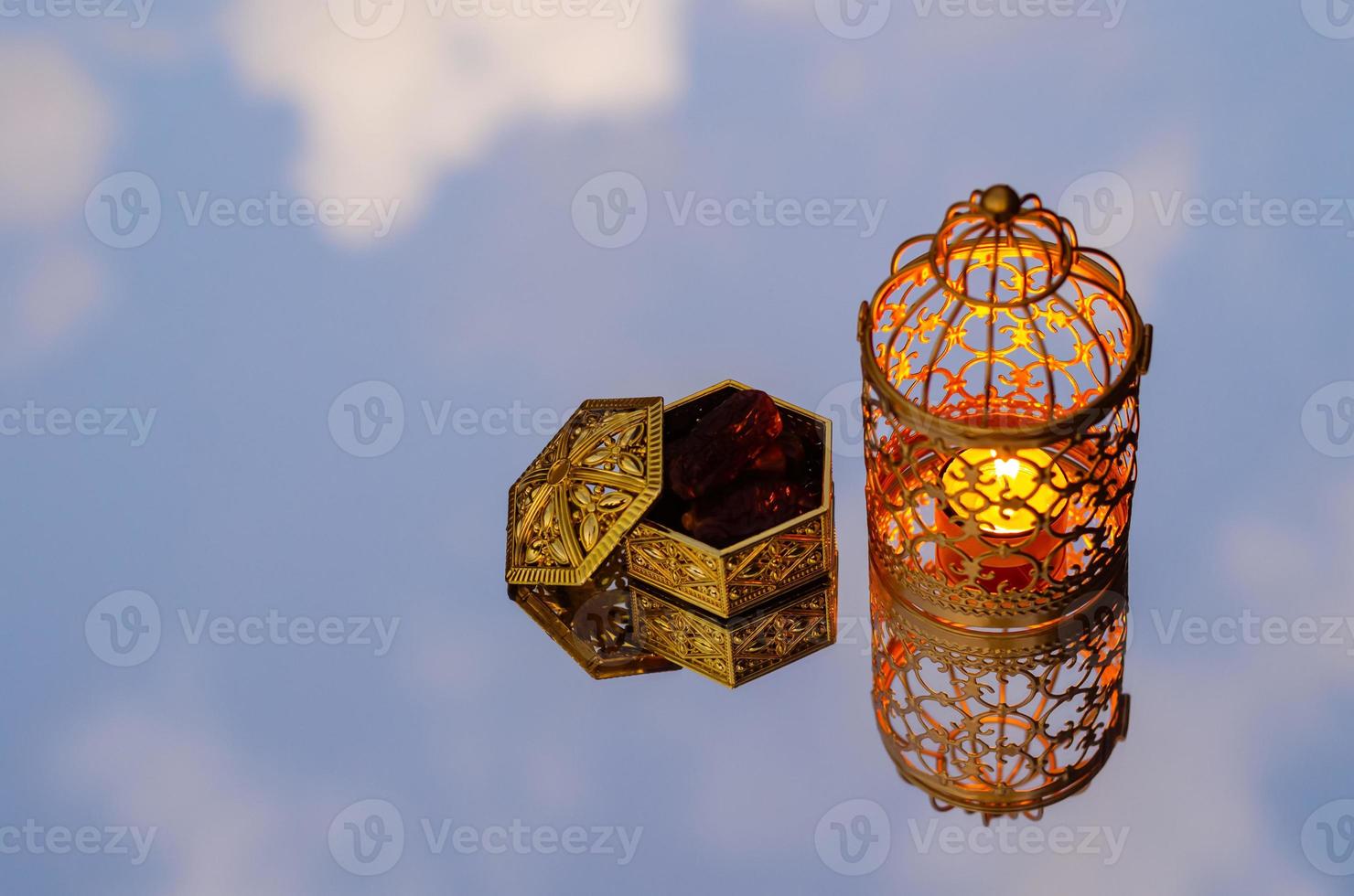 goldene laterne mit dattelfruchtreflexion vom spiegelhintergrund für das muslimische fest des heiligen monats ramadan kareem. foto