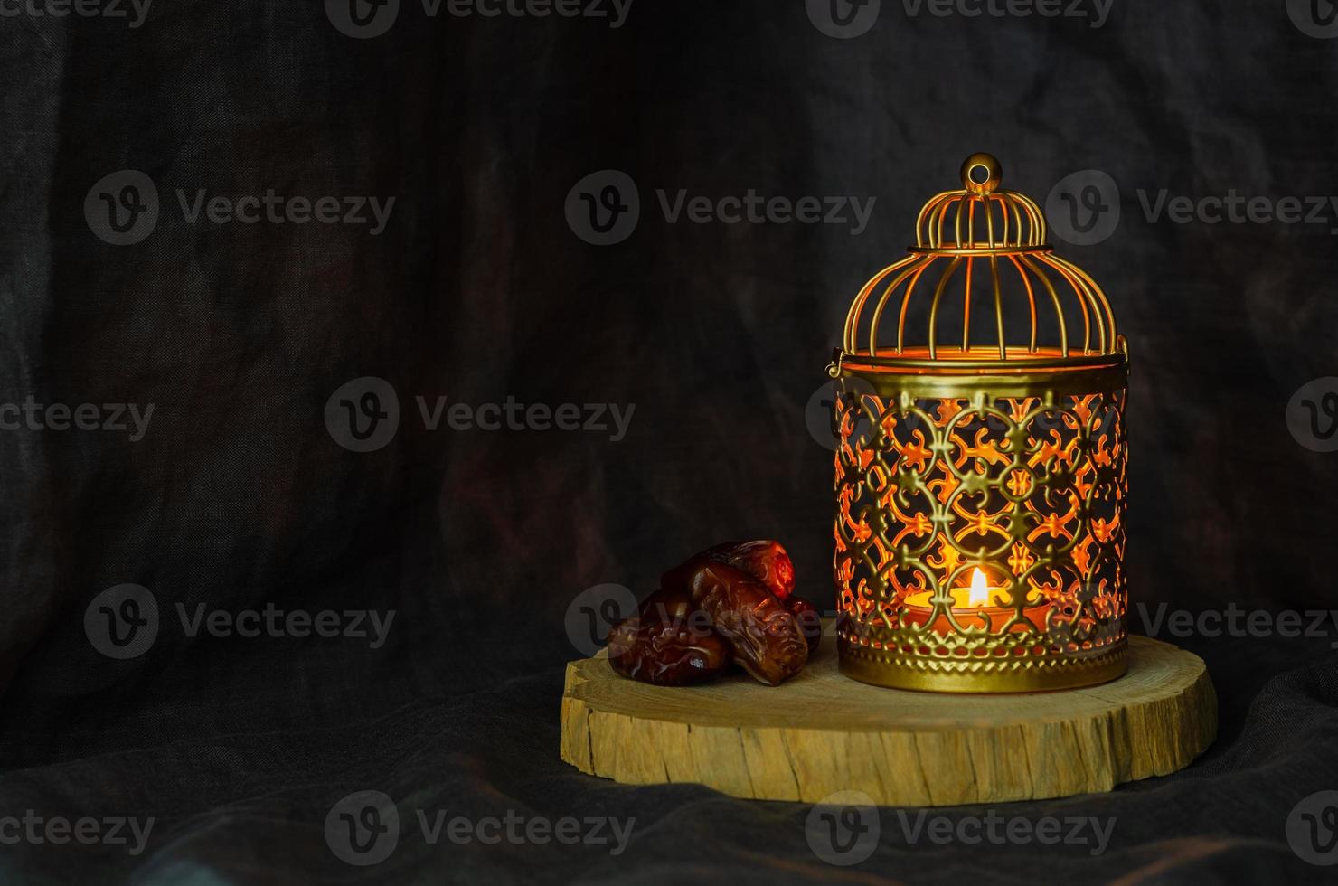 goldene laterne und dattelfrüchte auf dunklem hintergrund für das muslimische fest des heiligen monats ramadan kareem. foto