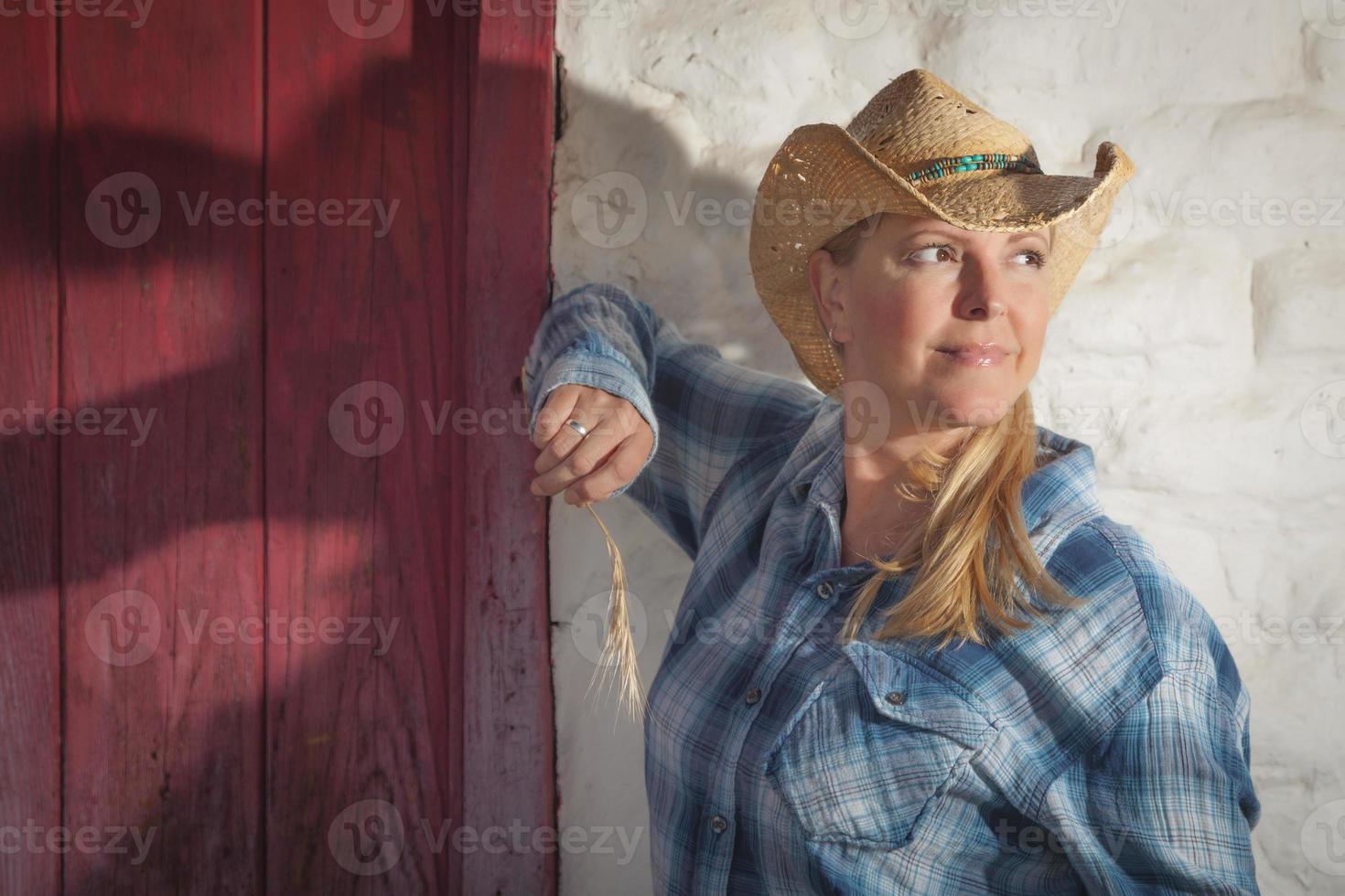 Schönes Cowgirl gegen alte Mauer und rote Tür foto