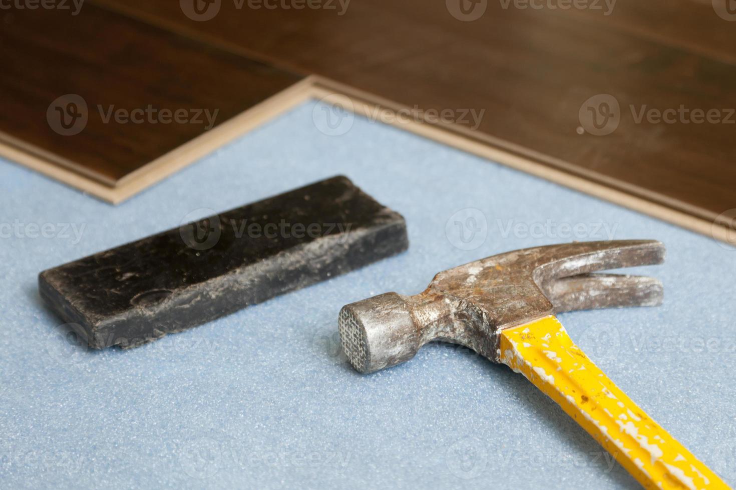 Hammer und Klotz mit neuem Laminatboden foto