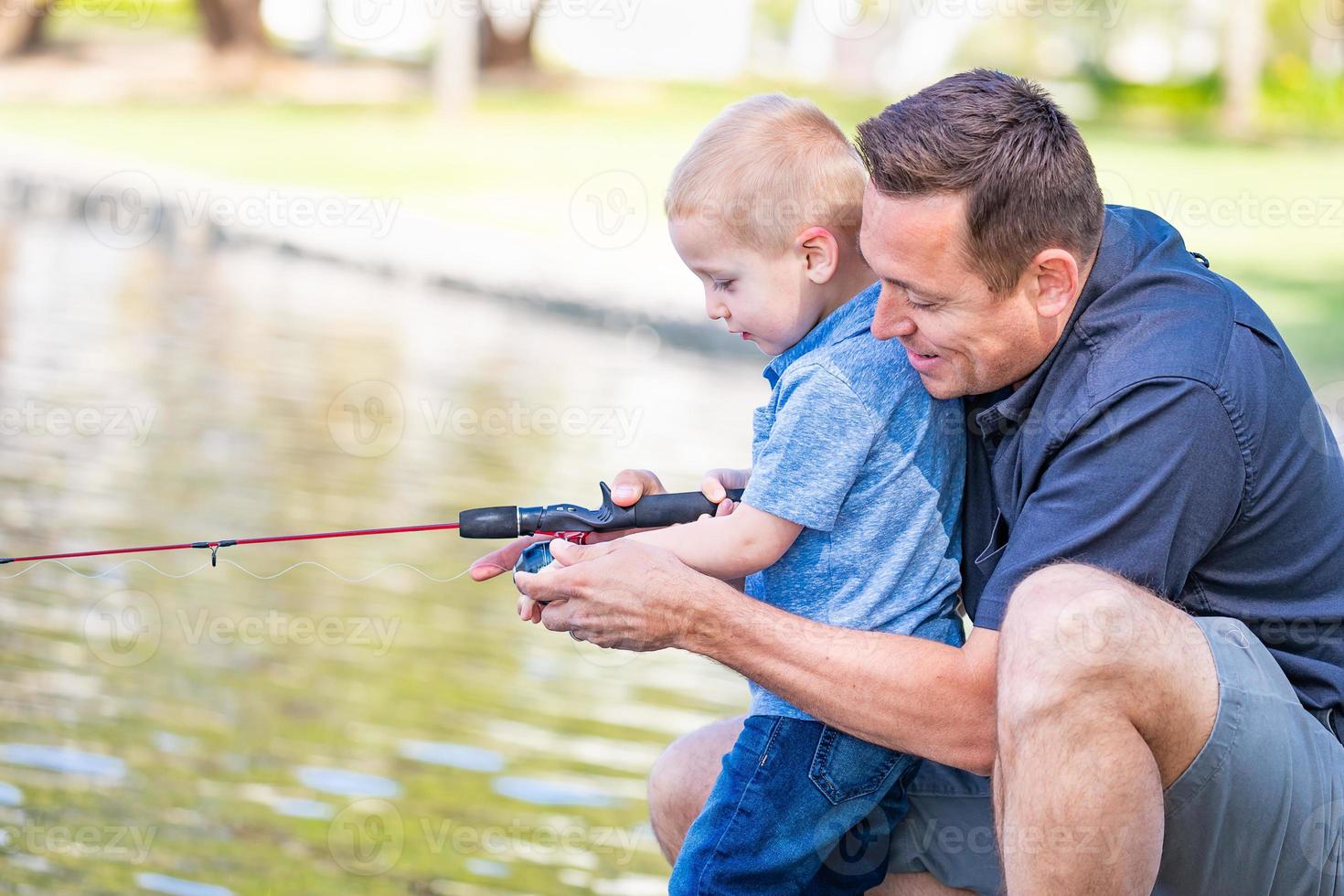 Junger kaukasischer Vater und Sohn haben Spaß beim Angeln am See foto