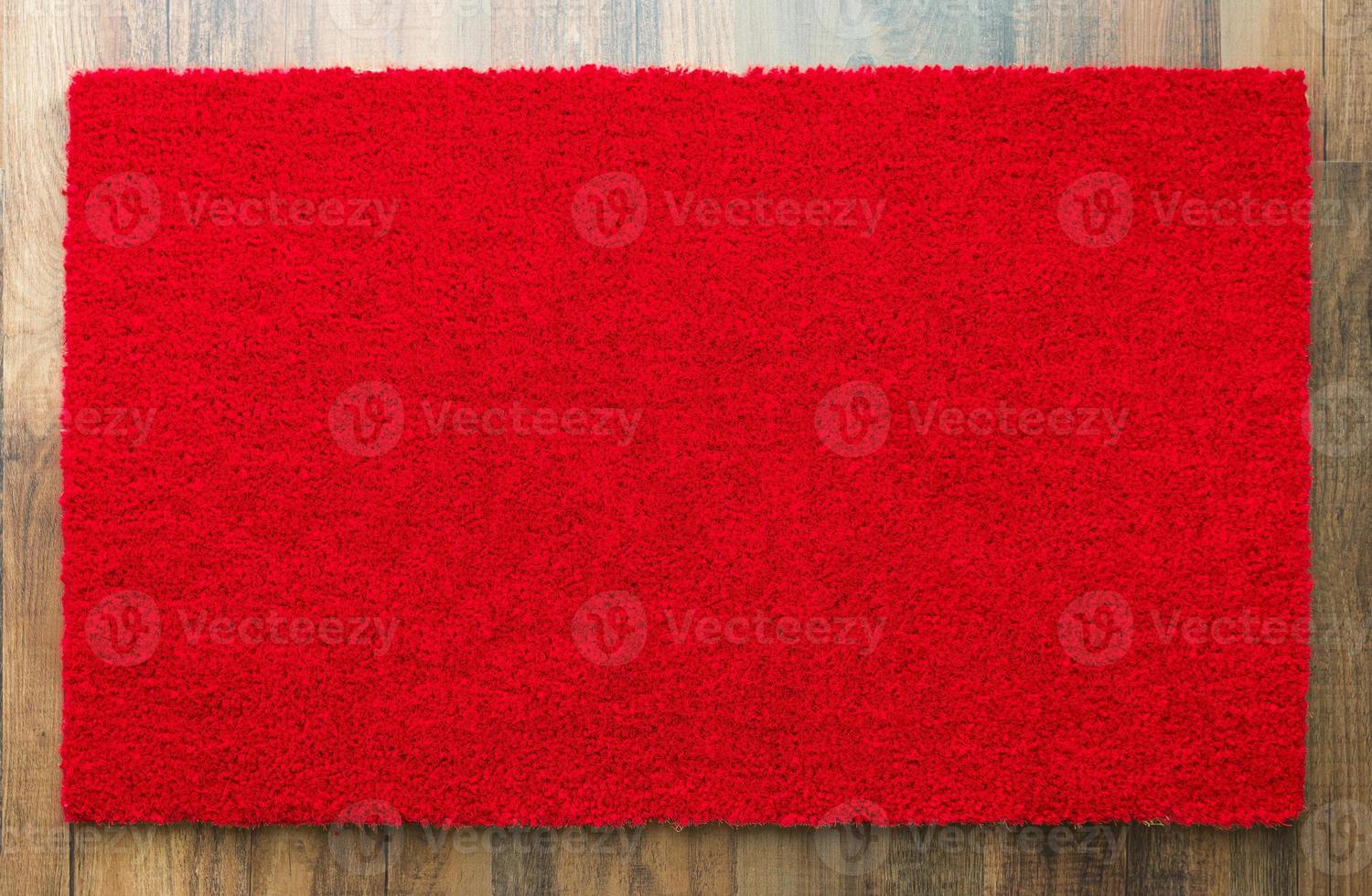leere rote willkommensmatte auf holzbodenhintergrund bereit für ihren eigenen text foto
