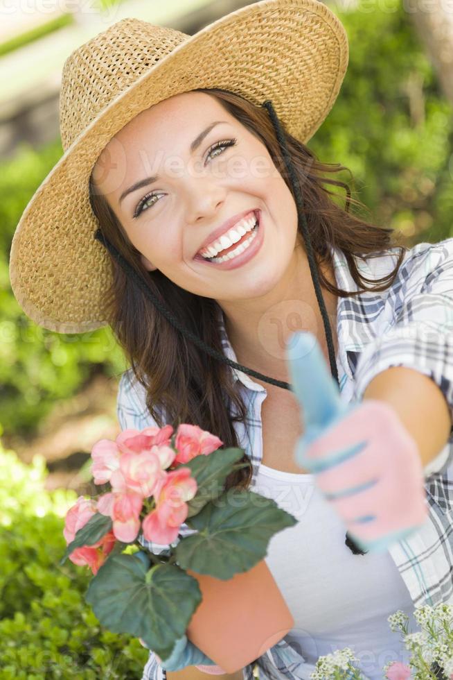 junge erwachsene Frau mit Hut Gartenarbeit im Freien foto