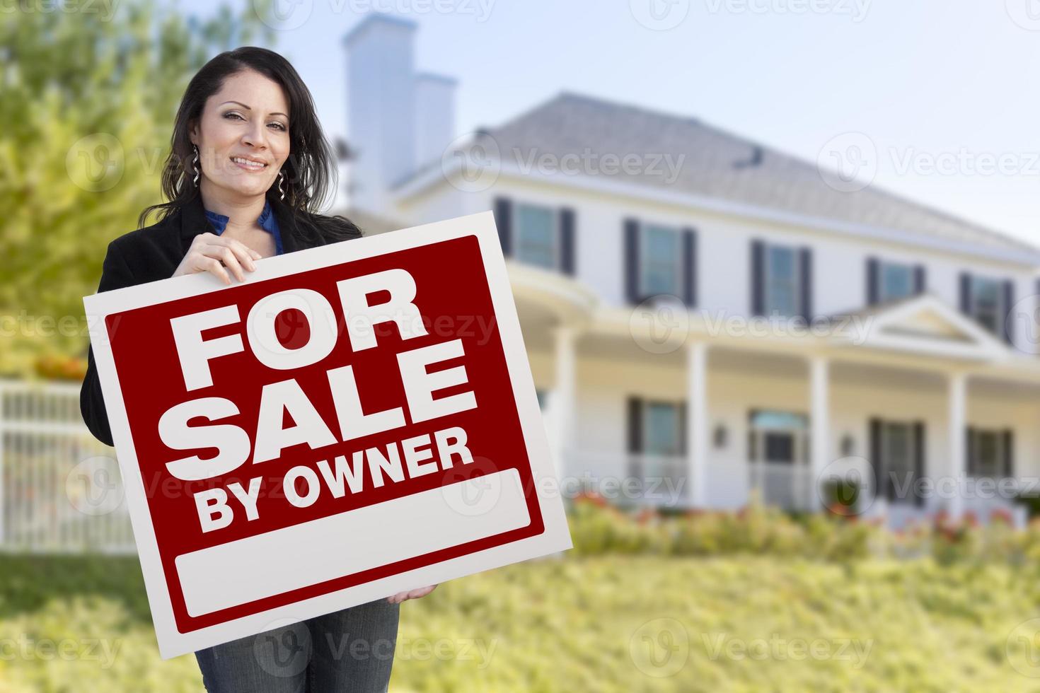 weibliche Holding Verkauf durch Besitzer Schild vor dem Haus foto