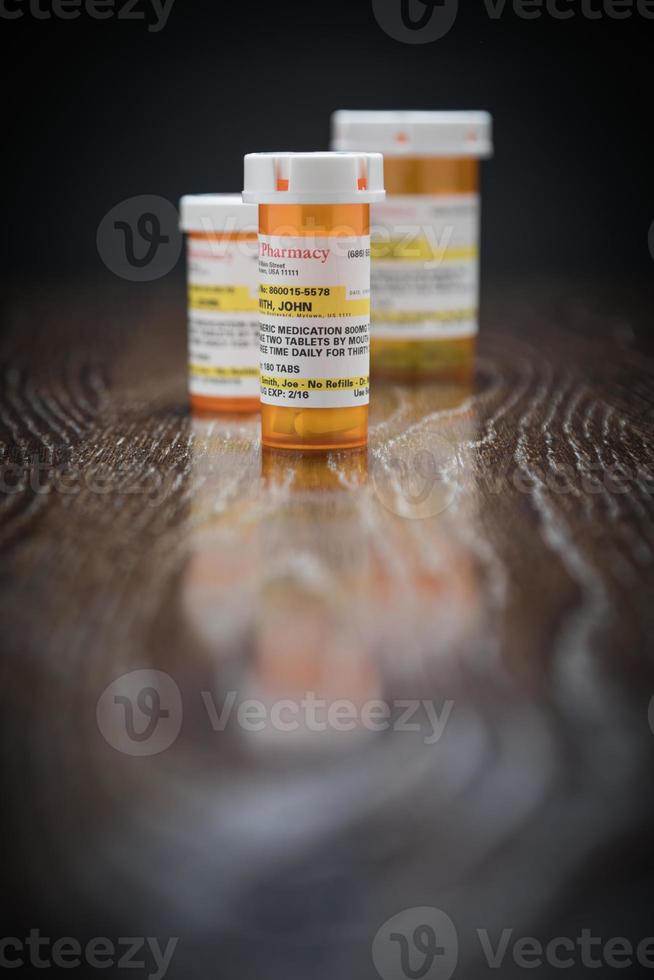 Vielzahl von nicht proprietären verschreibungspflichtigen Medikamentenflaschen auf reflektierender Holzoberfläche. foto