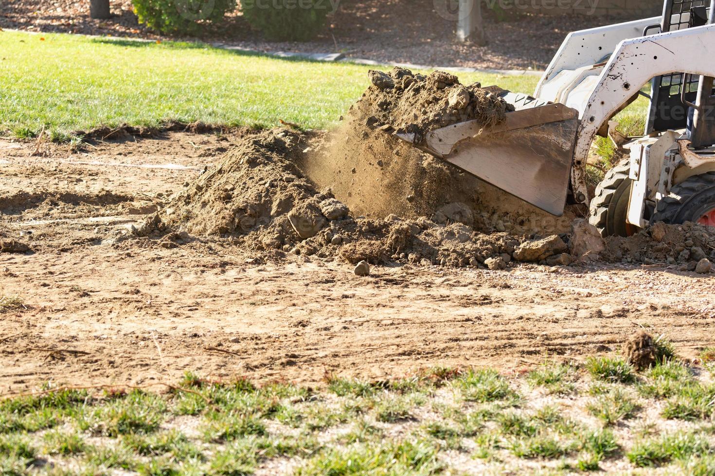 kleiner Bulldozer, der im Hof für die Poolinstallation gräbt foto